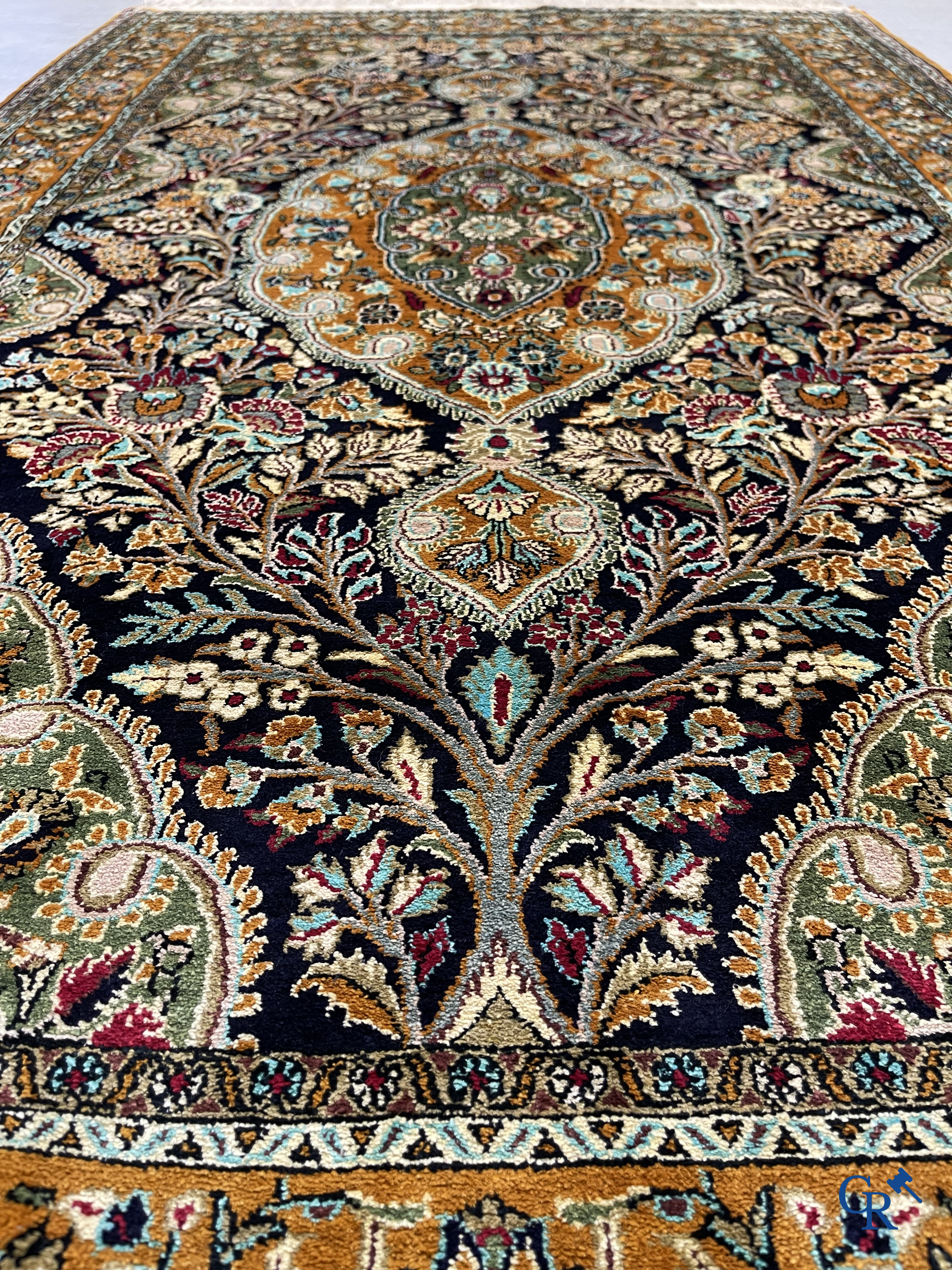 Oriental carpets. Hand-knotted silk carpet with floral decor on an orange background.