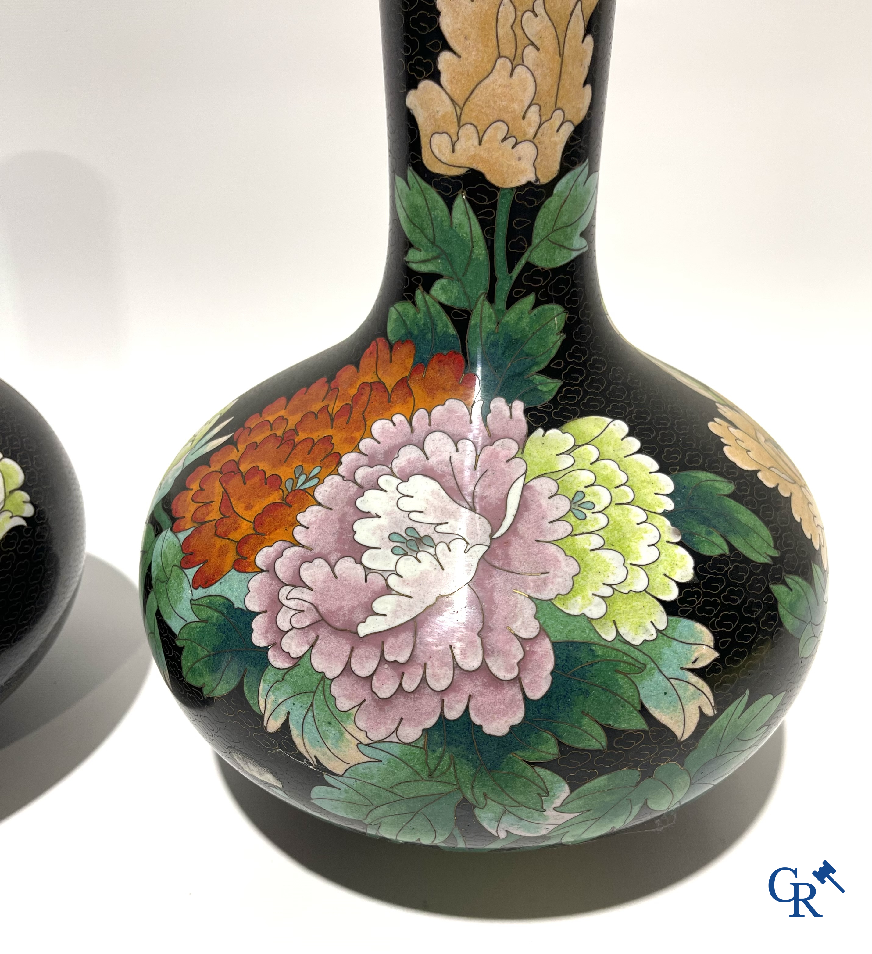 A pair of Chinese cloisonne vases with floral decor.