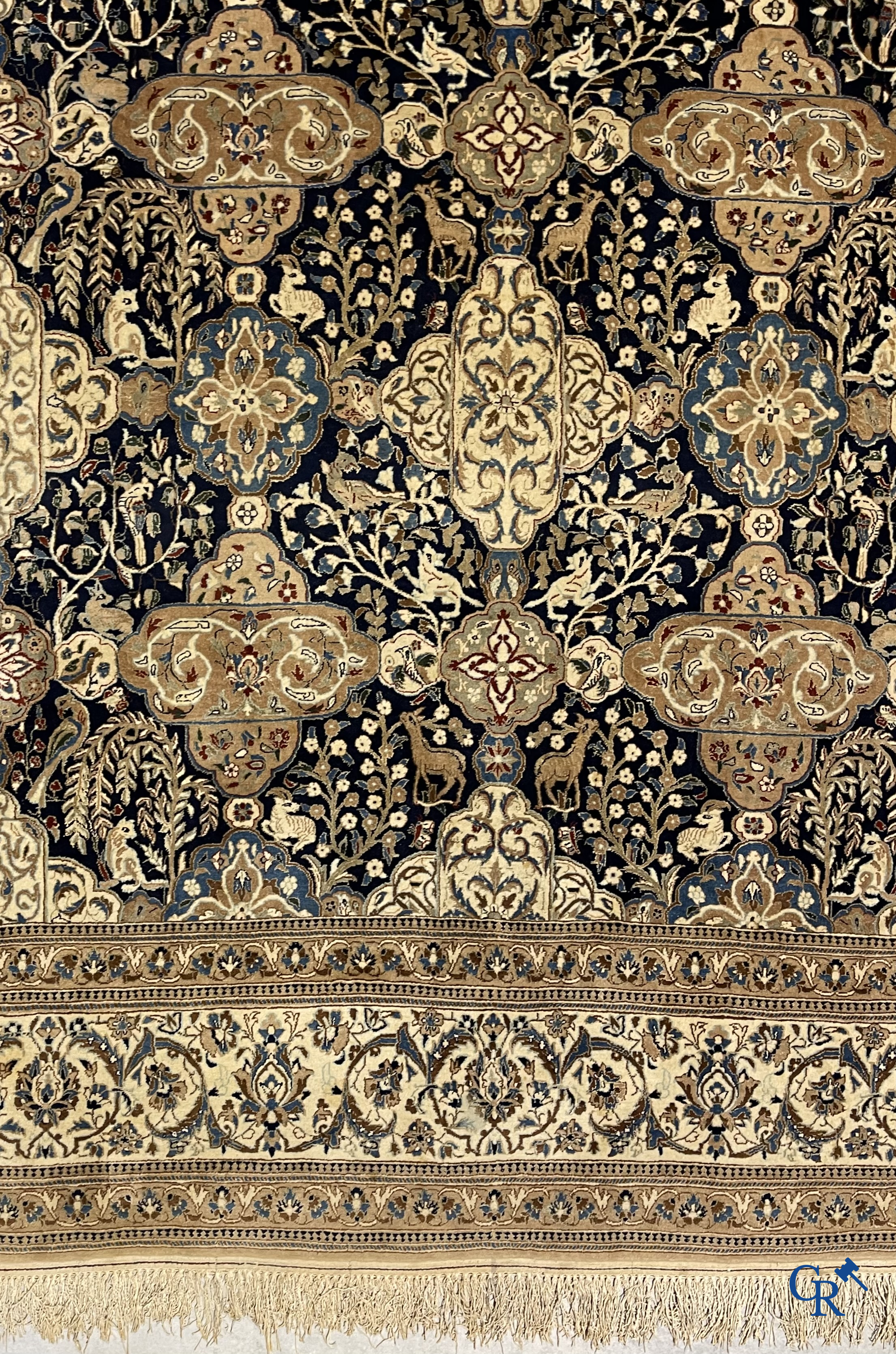 Oosterse tapijten. Een handgeknoopt tapijt met wouddieren en bloemen.