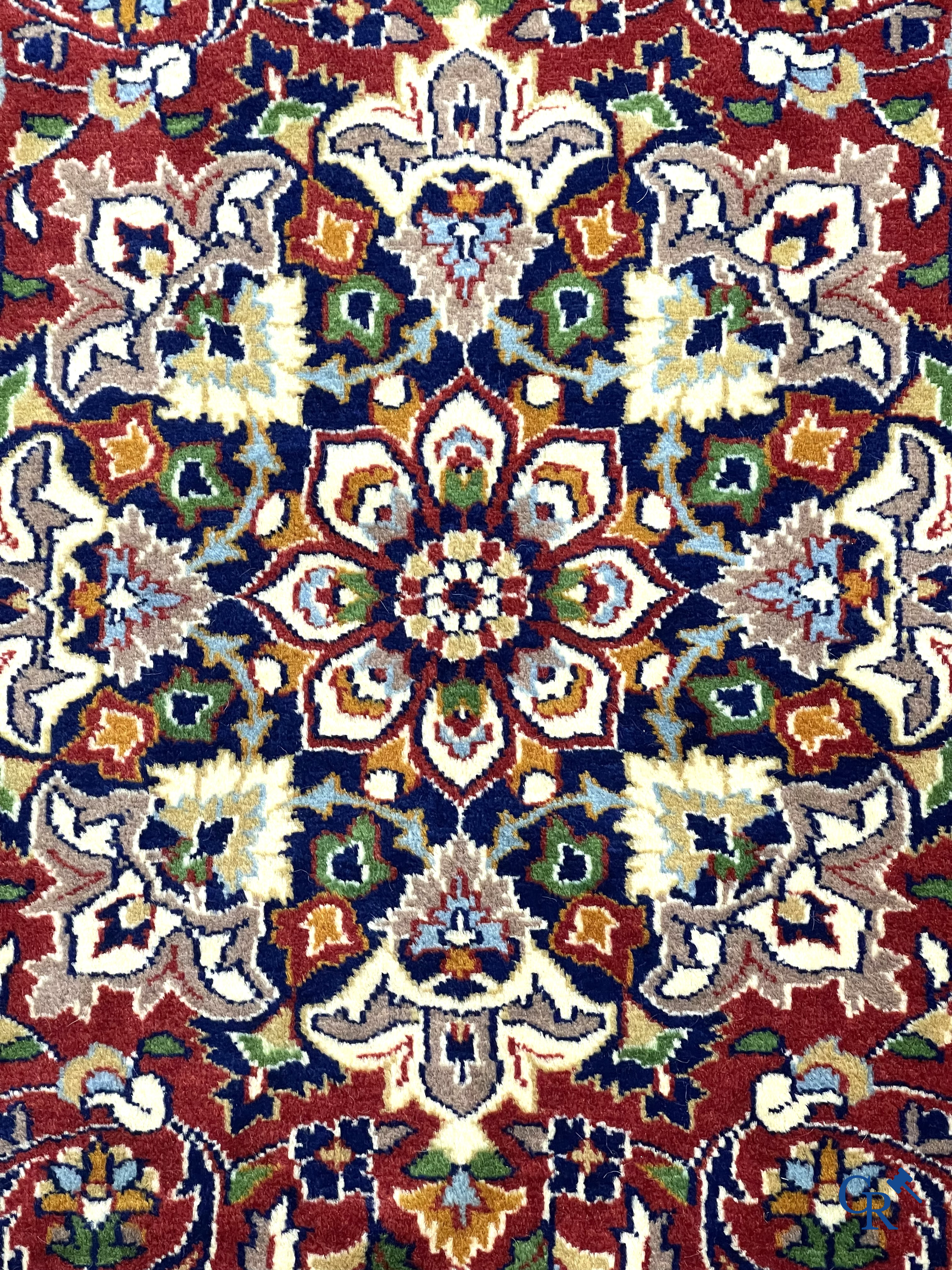 Oriental carpets. Finely hand-knotted carpet with floral decor on a dark red background.