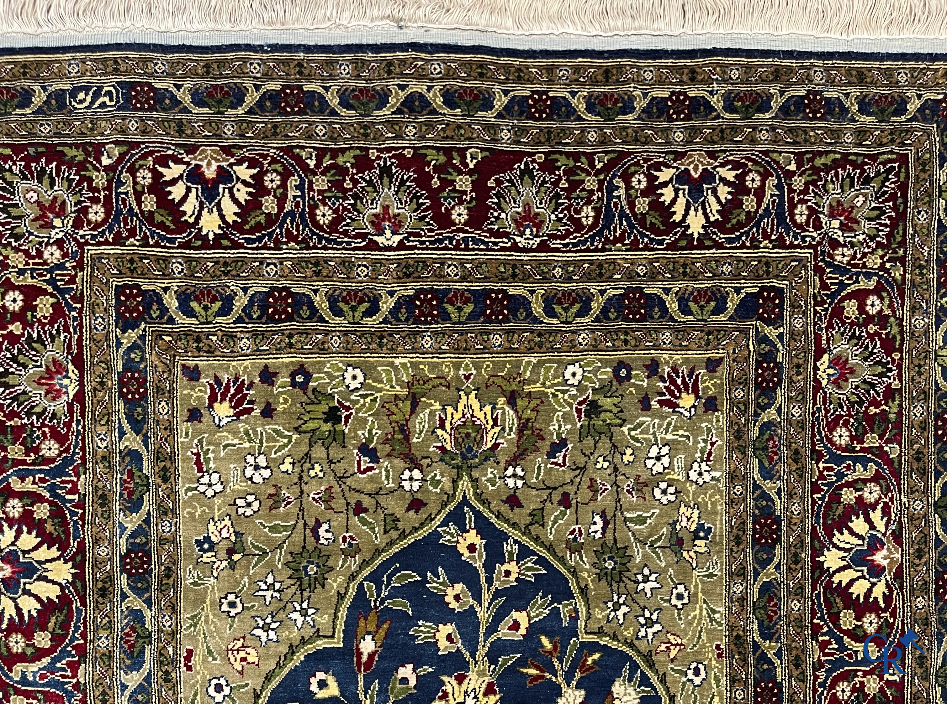 Oosterse tapijten. Een uiterst fijn geknoopt zijden tapijt met floraal decor op donker blauwe achtergrond en gouddraad.