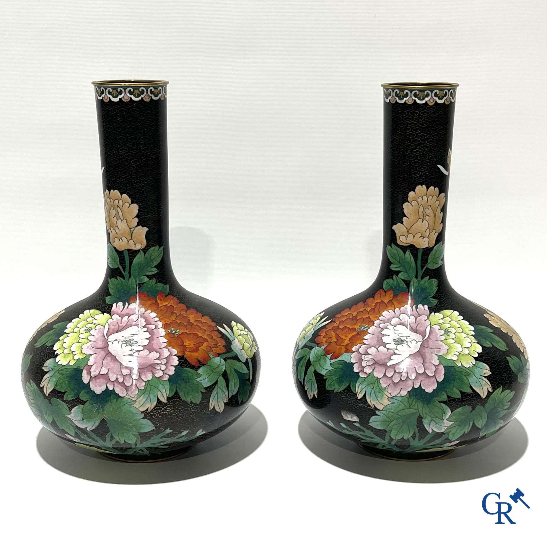 A pair of Chinese cloisonne vases with floral decor.