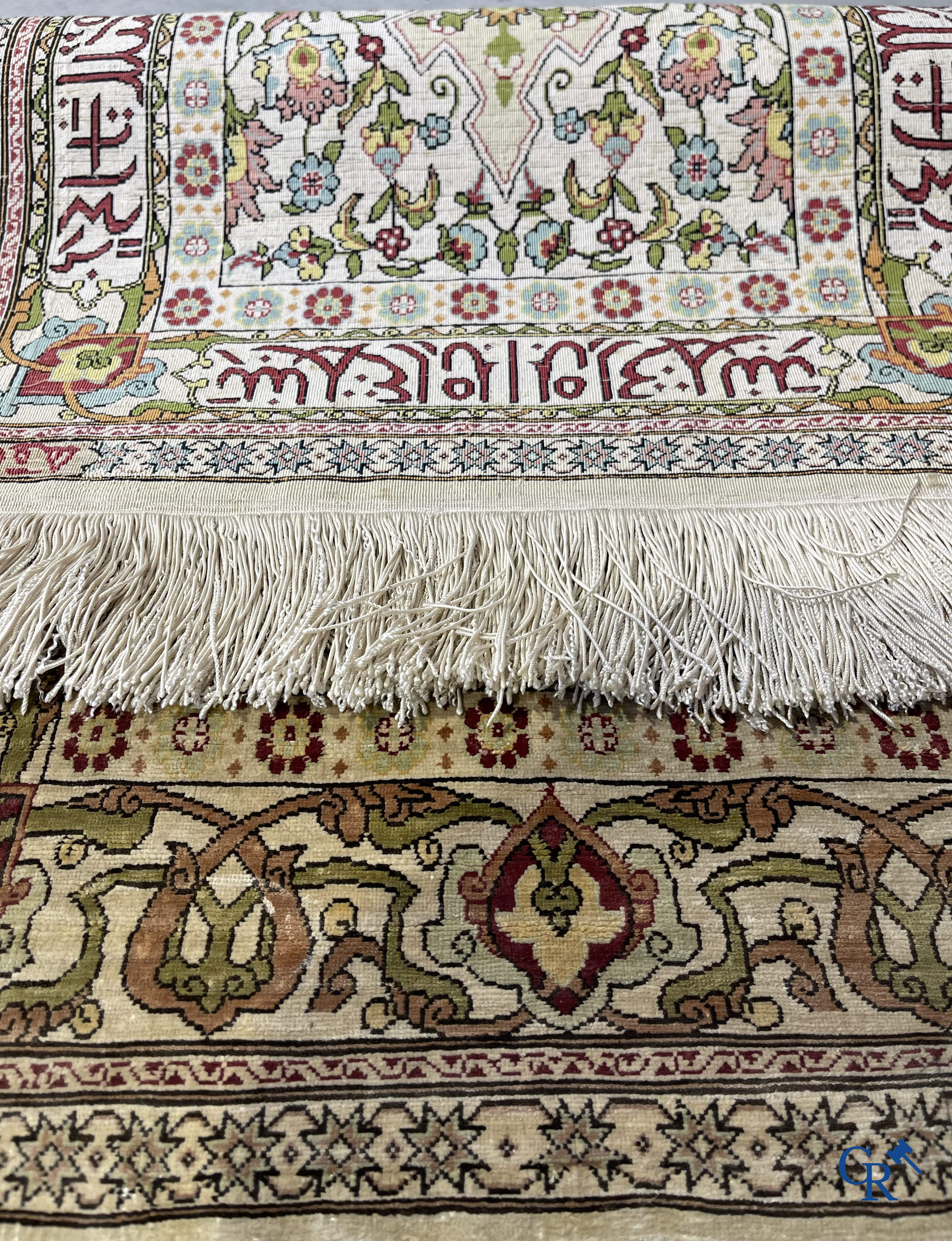 Oosterse tapijten. Hereke, een zijden tapijtje met inscripties. Gesigneerd.