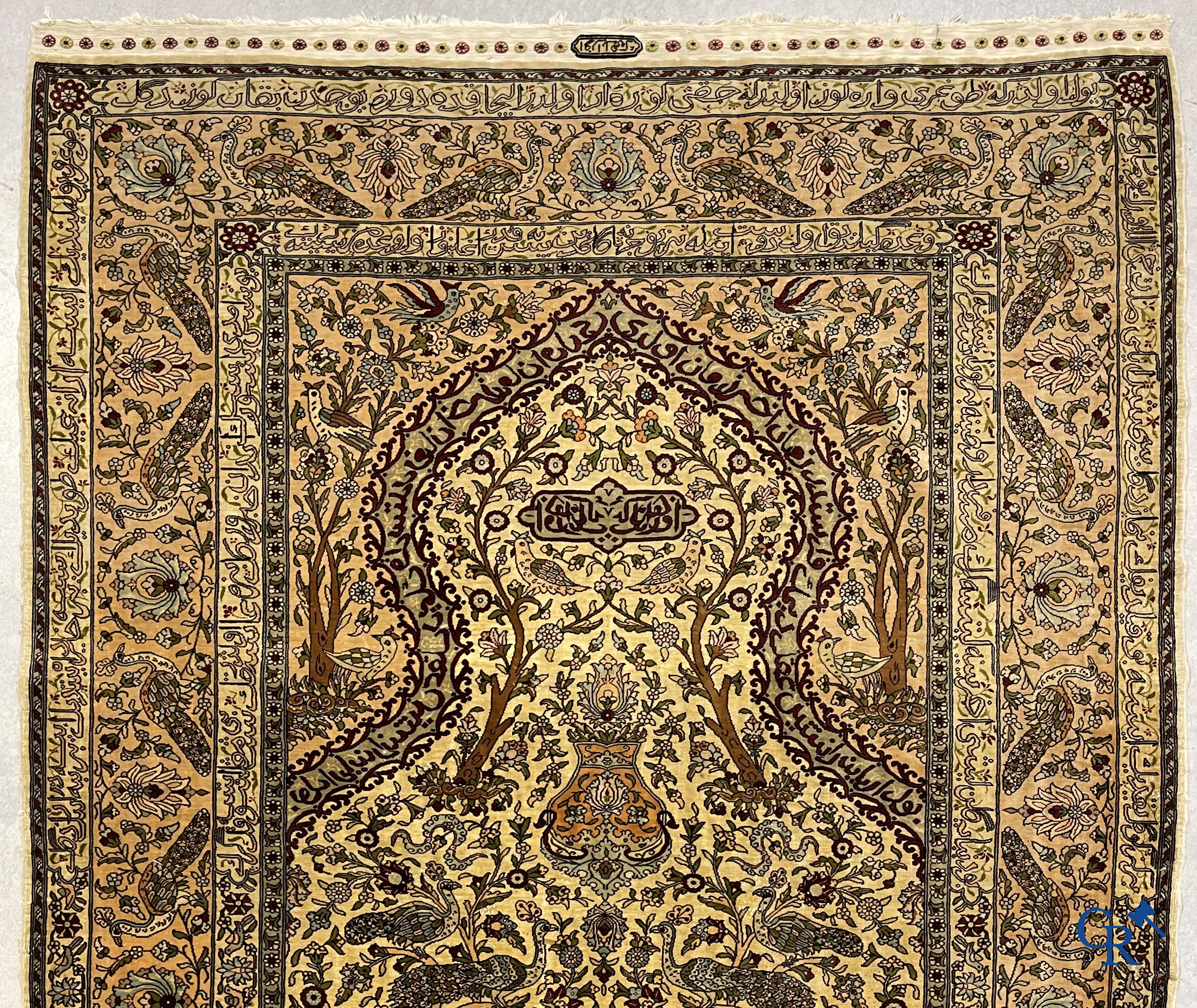 Oriental carpets. Hereke. A finely hand-knotted silk carpet with birds in the forest. Inscriptions and signed.