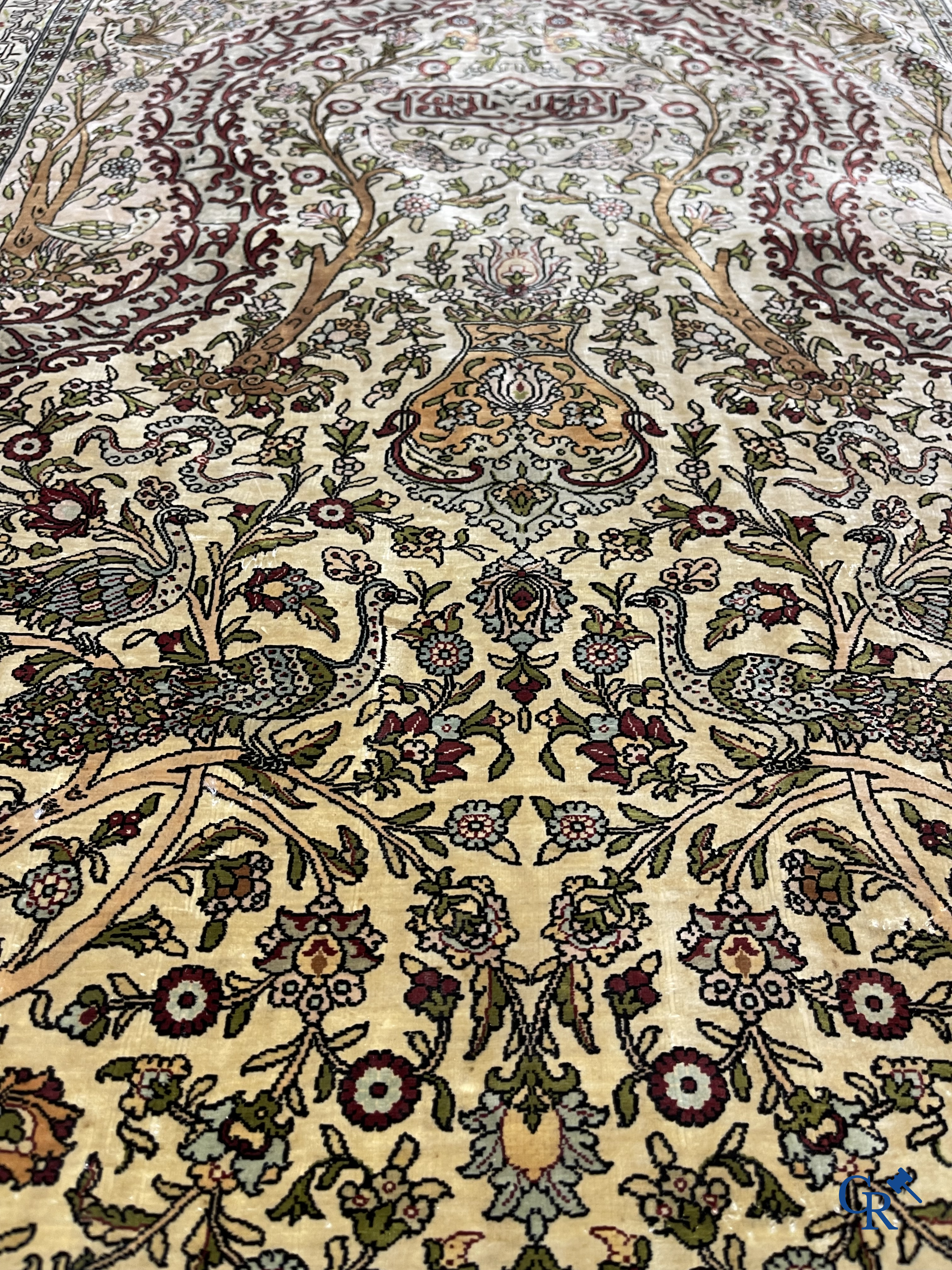 Oriental carpets. Hereke. A finely hand-knotted silk carpet with birds in the forest. Inscriptions and signed.