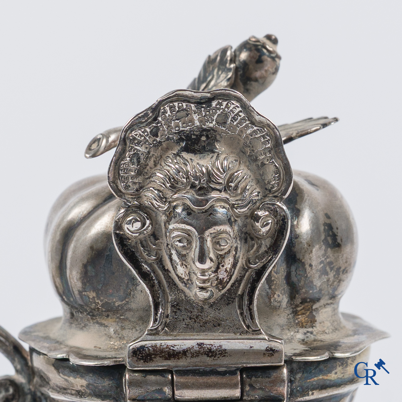 Zilver. Mosterdpot in zilver. Duimsteun met masker. Vermoedelijk België, 18e eeuw.