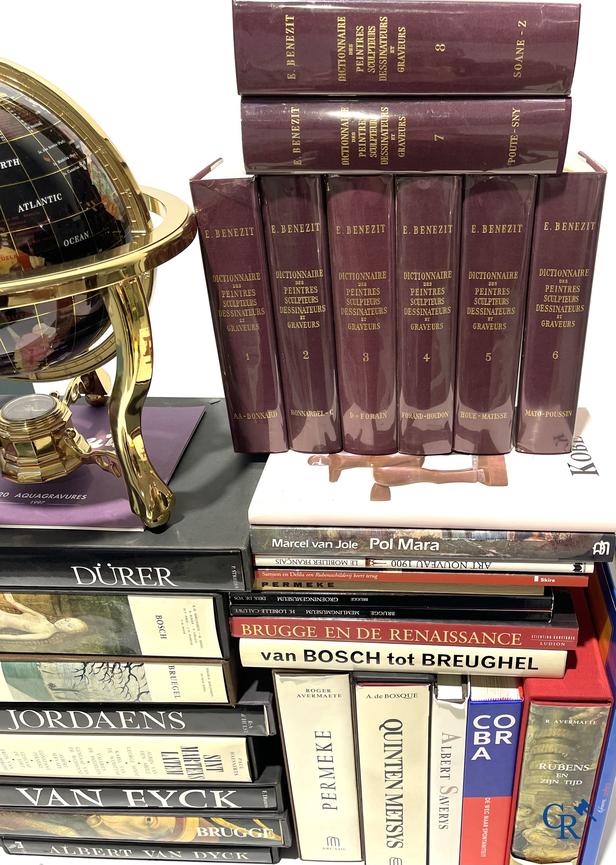 Groot lot kunstboeken, het Bénézit-woordenboek en een decoratieve moderne wereldbol.