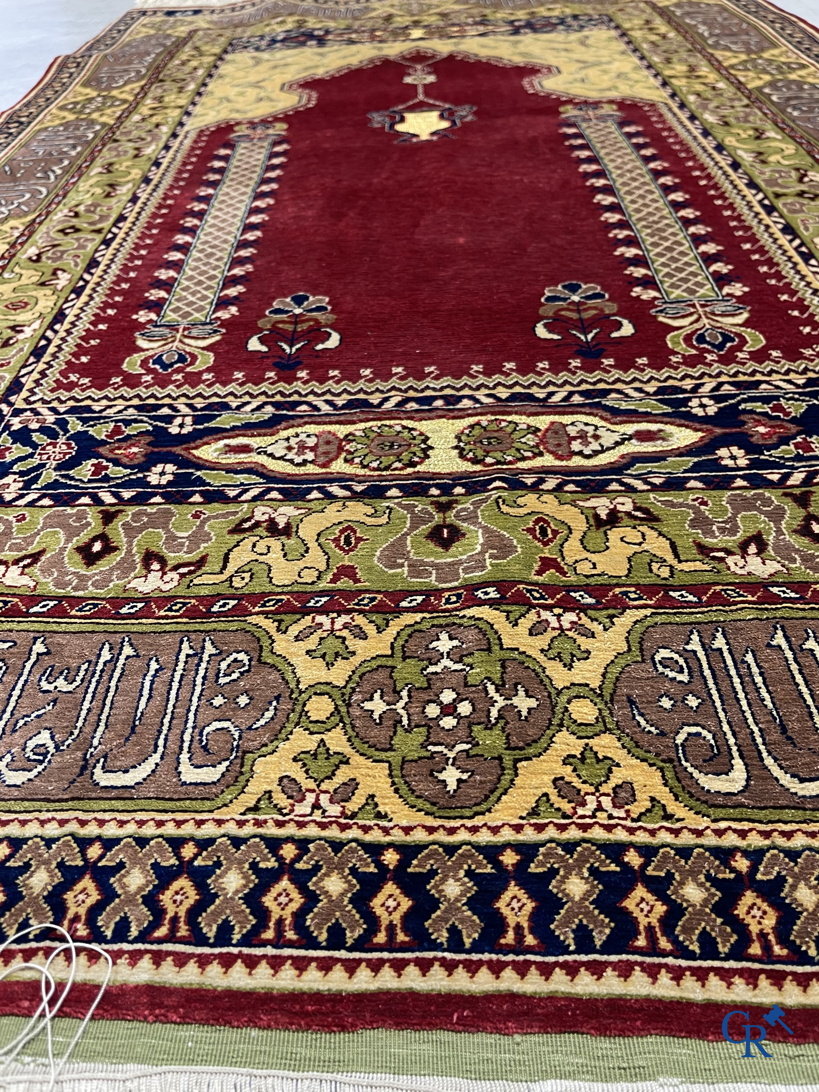 Oosterse tapijten. Een uiterst fijn handgeknoopt zijden tapijt met inscripties en gouddraad. Gesigneerd.