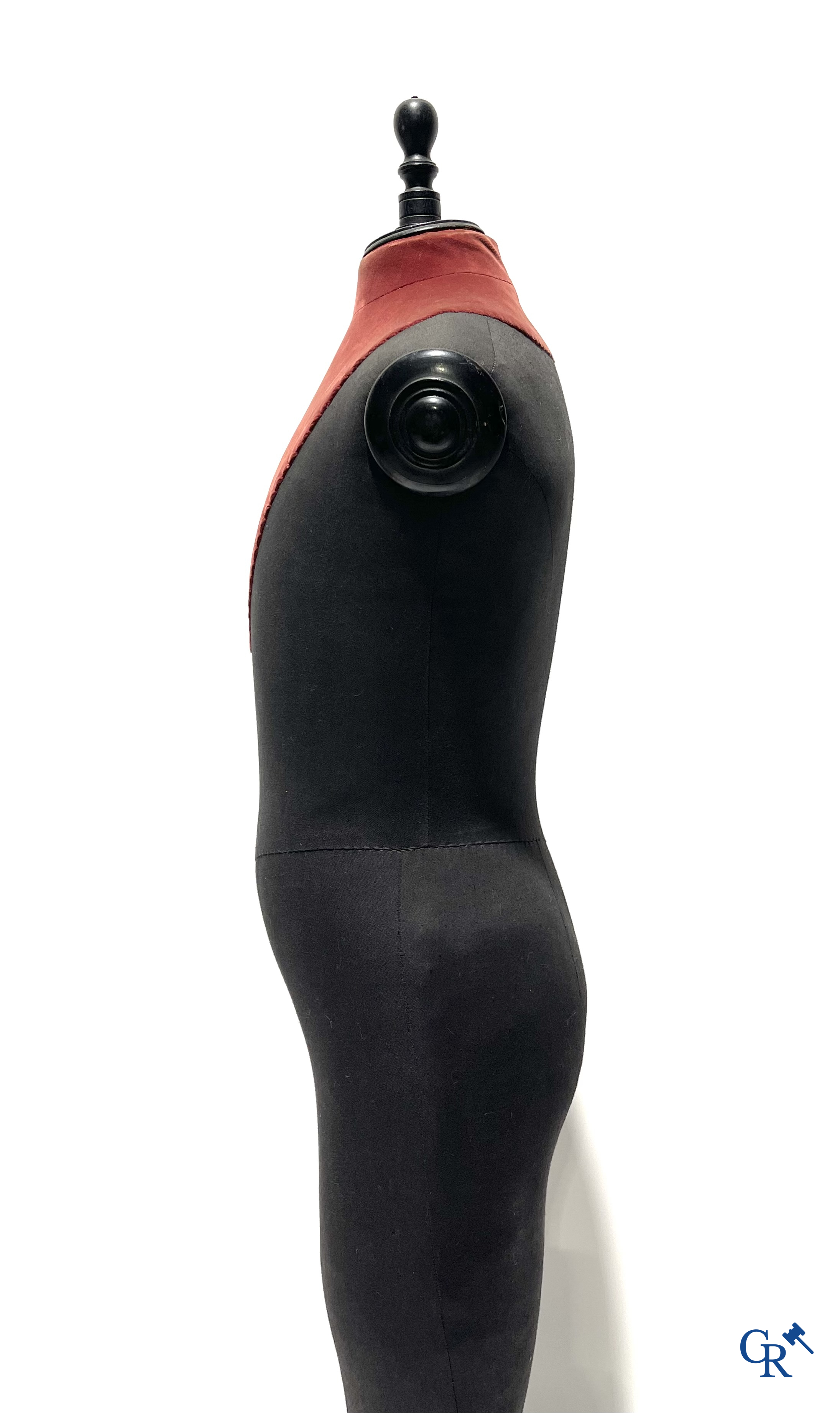 Een kindermannequin met houten laarzen en zwarte stof in de stijl van Stockman. Circa 1900.