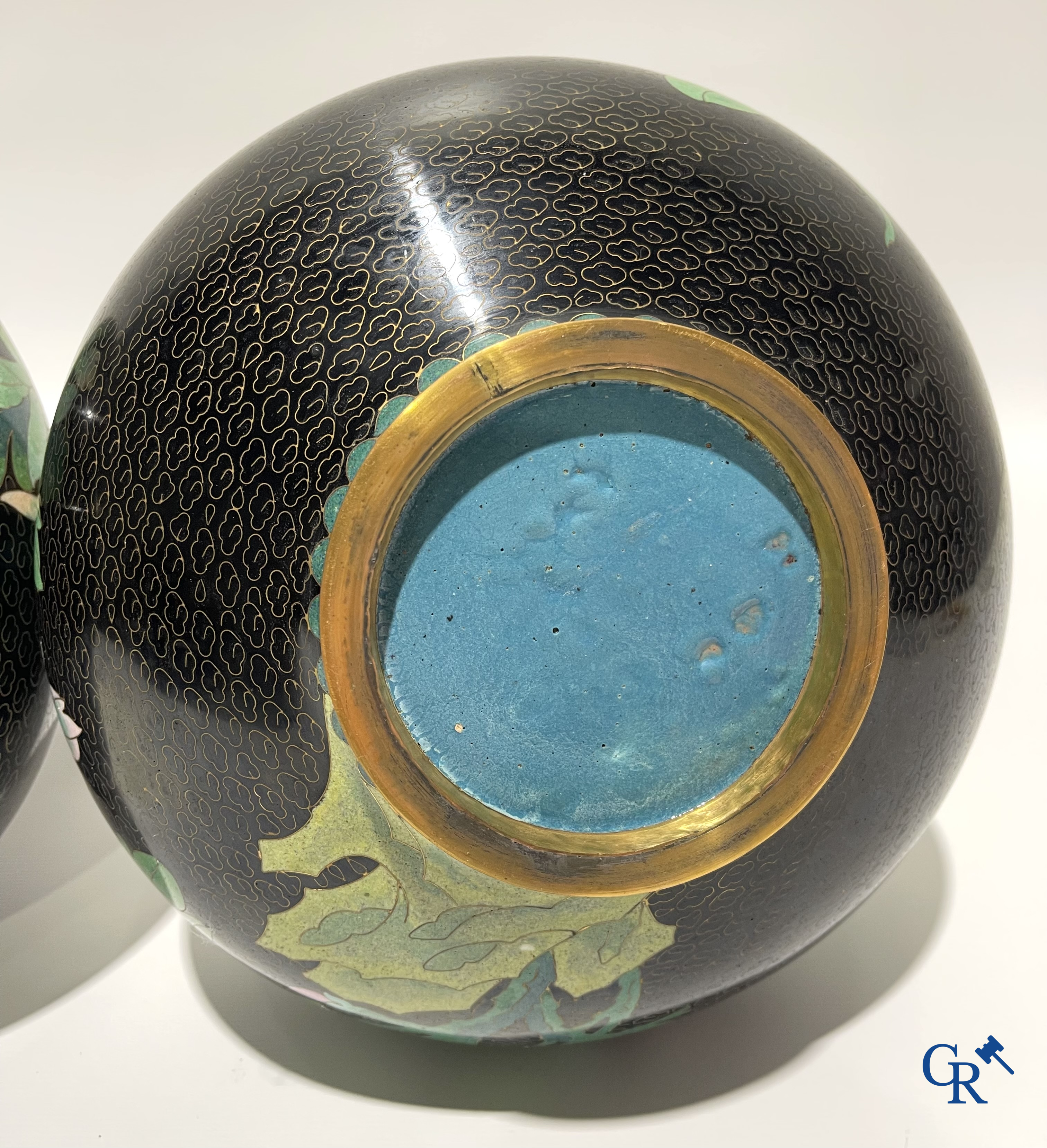 A pair of Chinese cloisonne vases with floral decor.