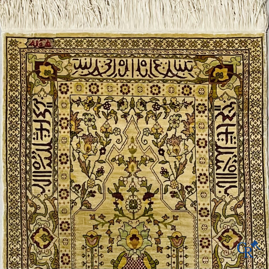 Oosterse tapijten. Hereke, een zijden tapijtje met inscripties. Gesigneerd.