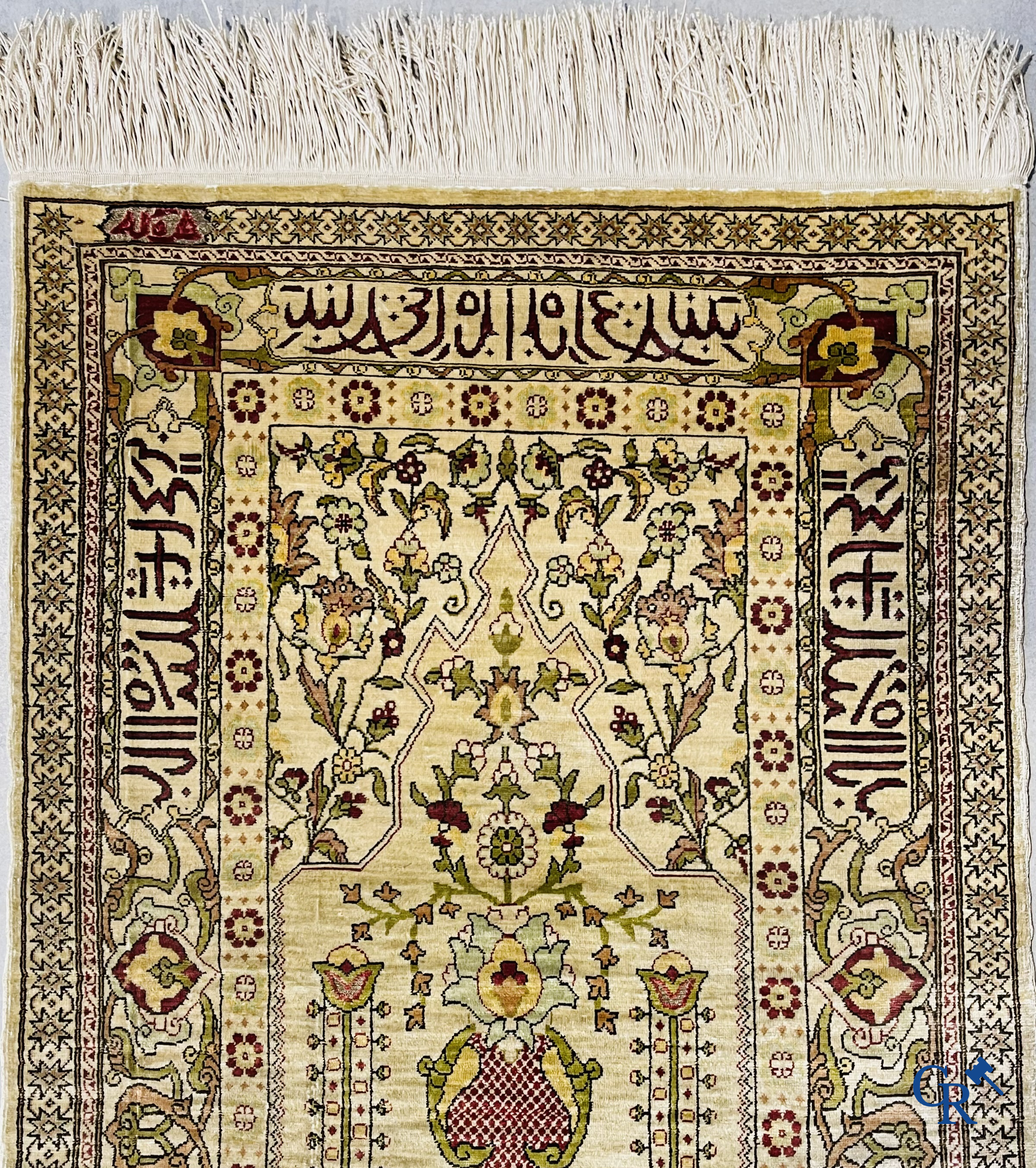 Oosterse tapijten. Hereke, een zijden tapijtje met inscripties. Gesigneerd.