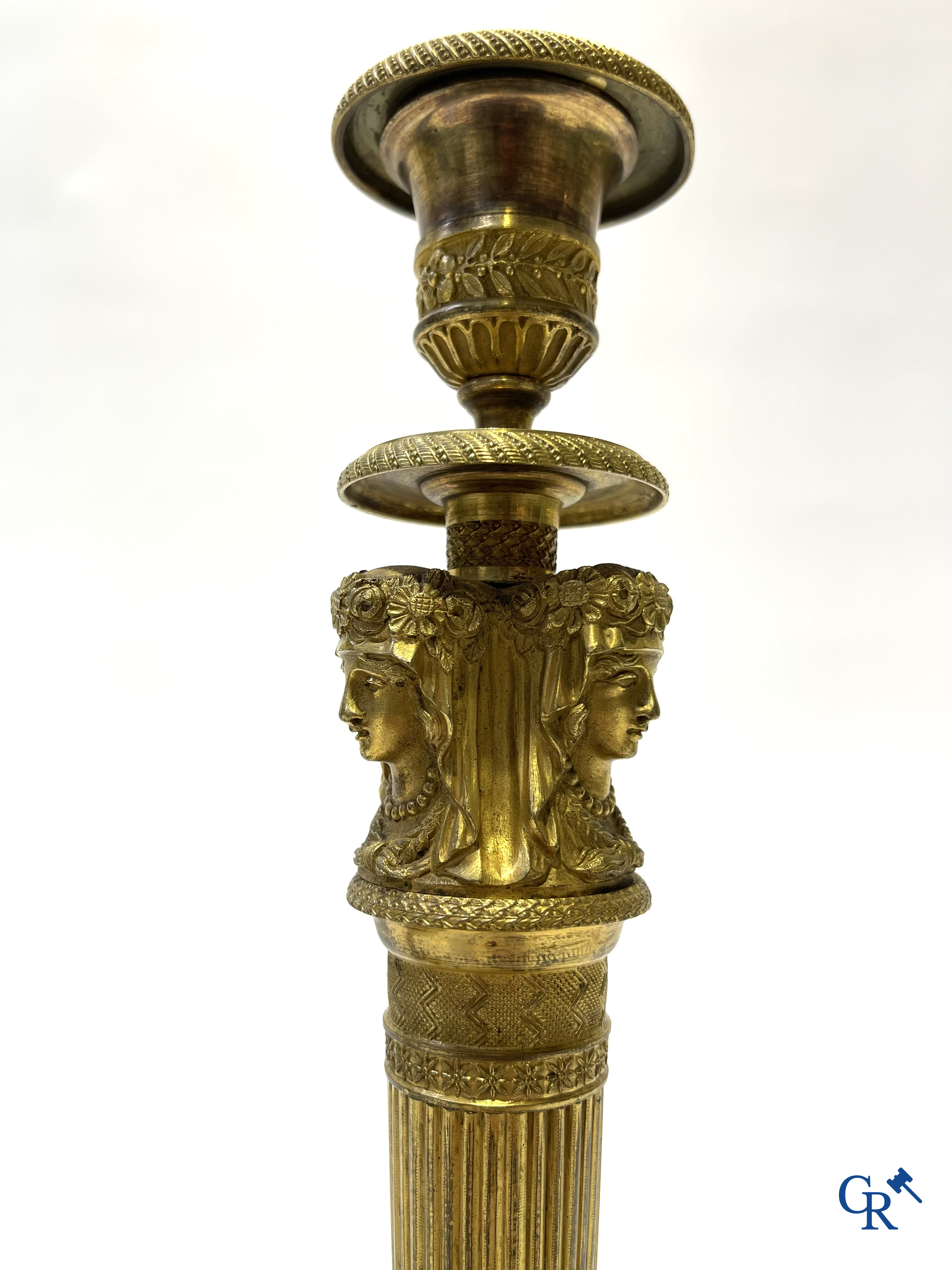 Empire. A pair of early 19th century bronze gilded candlesticks with caryatides. French work.