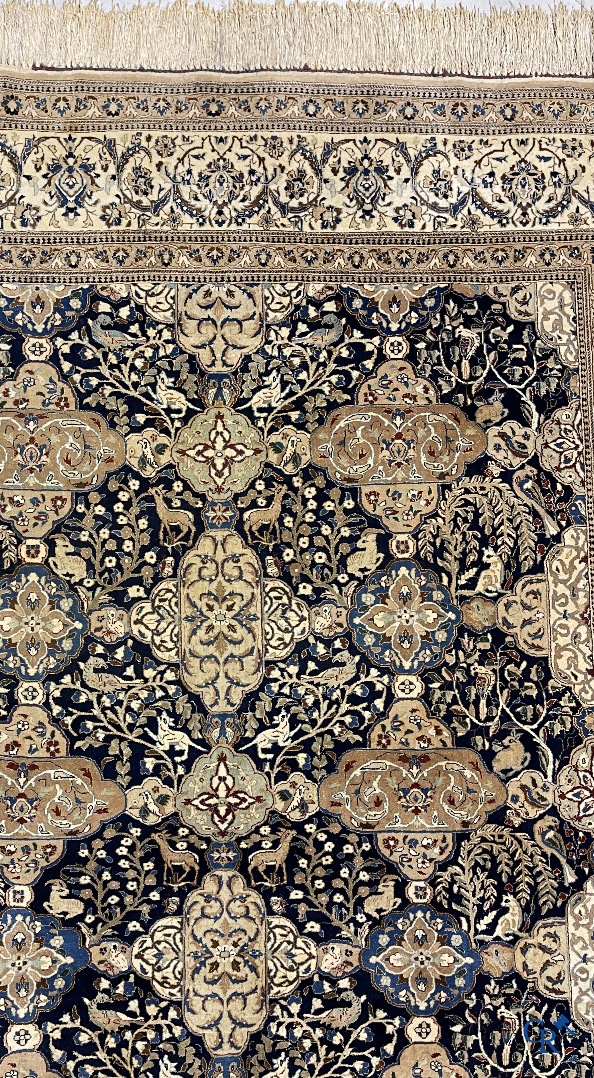 Oosterse tapijten. Een handgeknoopt tapijt met wouddieren en bloemen.