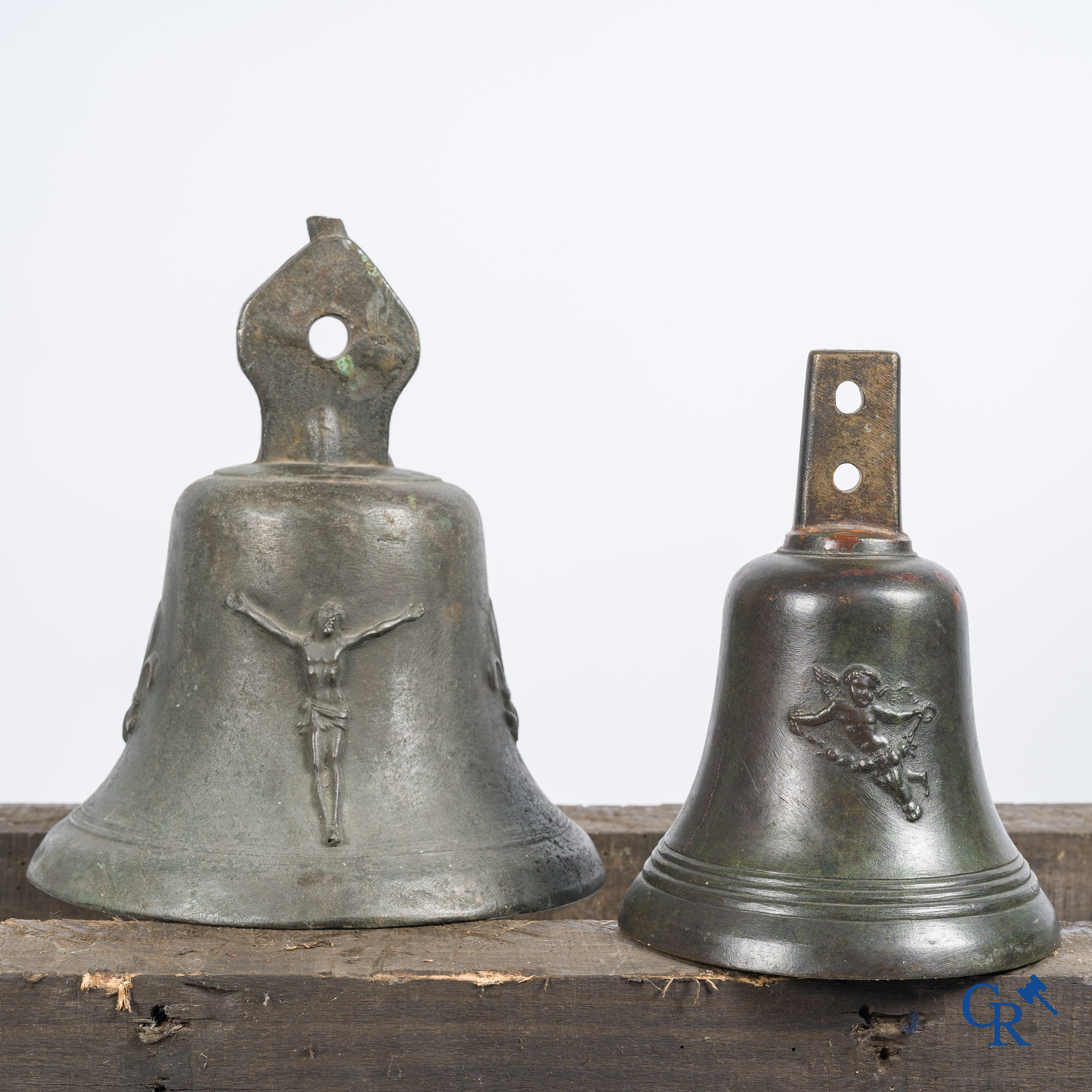 2 antique bronze bells. One decorated with "fleurs de lys" and Christ, the other decorated with an angel.