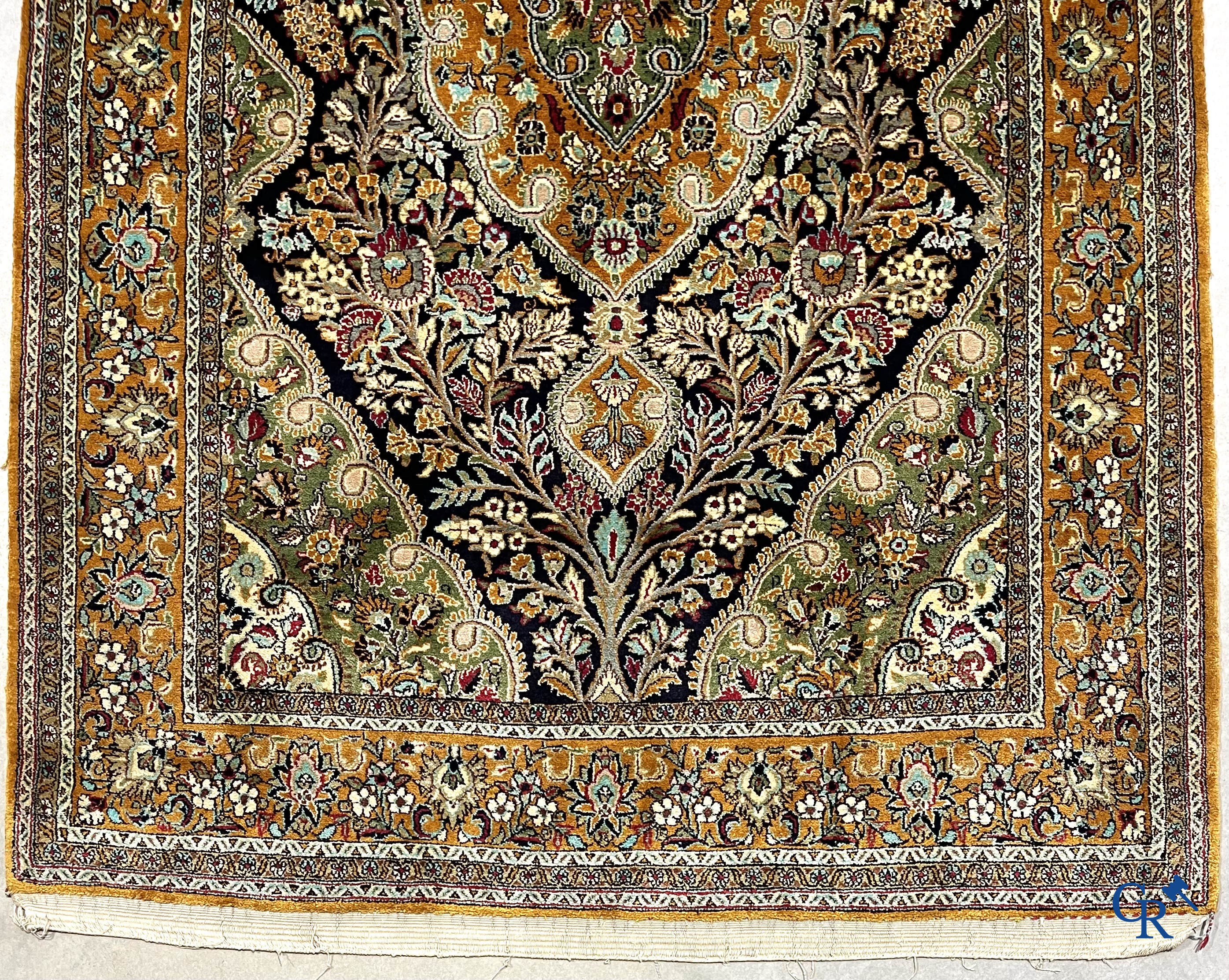 Oriental carpets. Hand-knotted silk carpet with floral decor on an orange background.