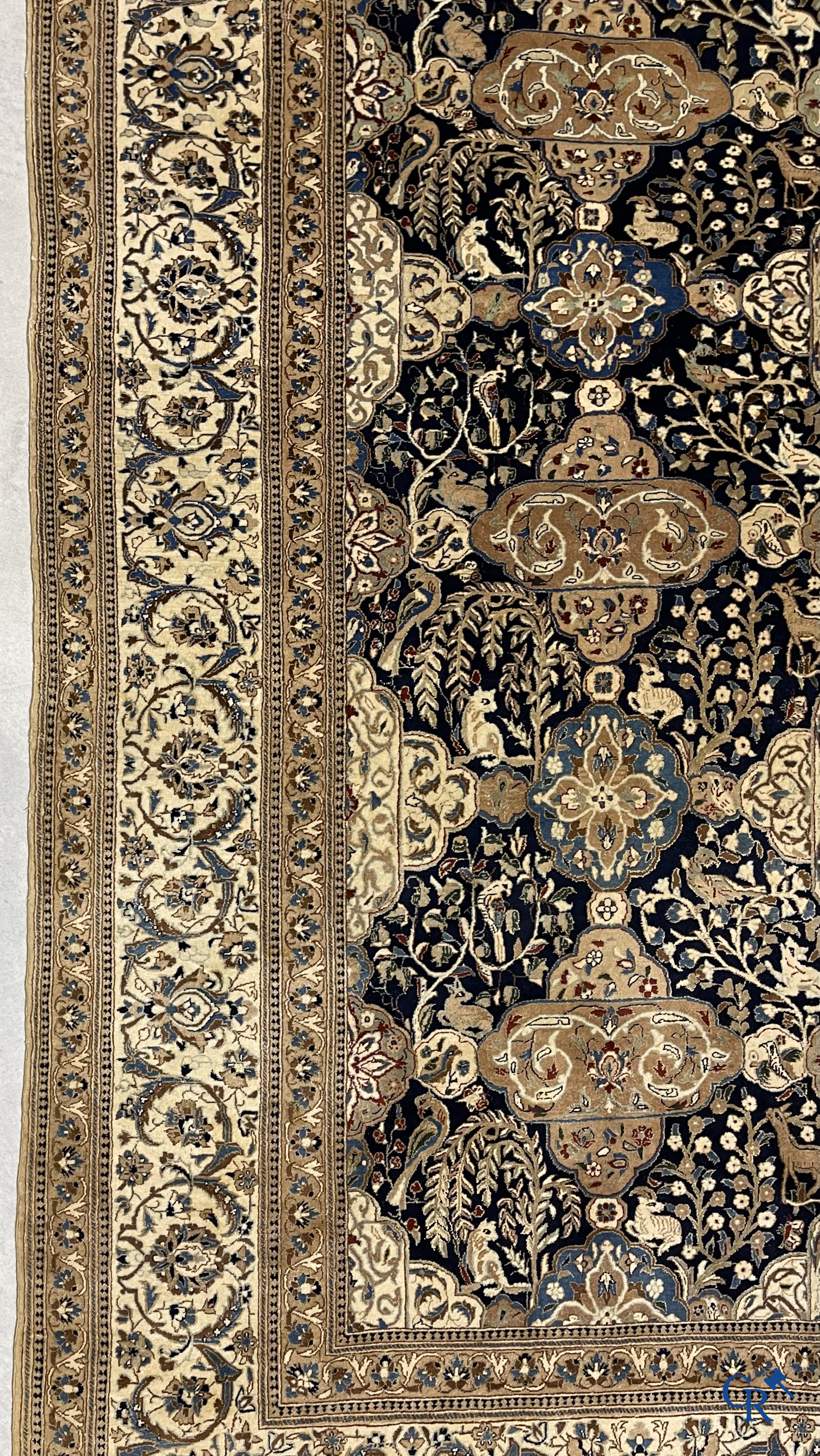 Oosterse tapijten. Een handgeknoopt tapijt met wouddieren en bloemen.