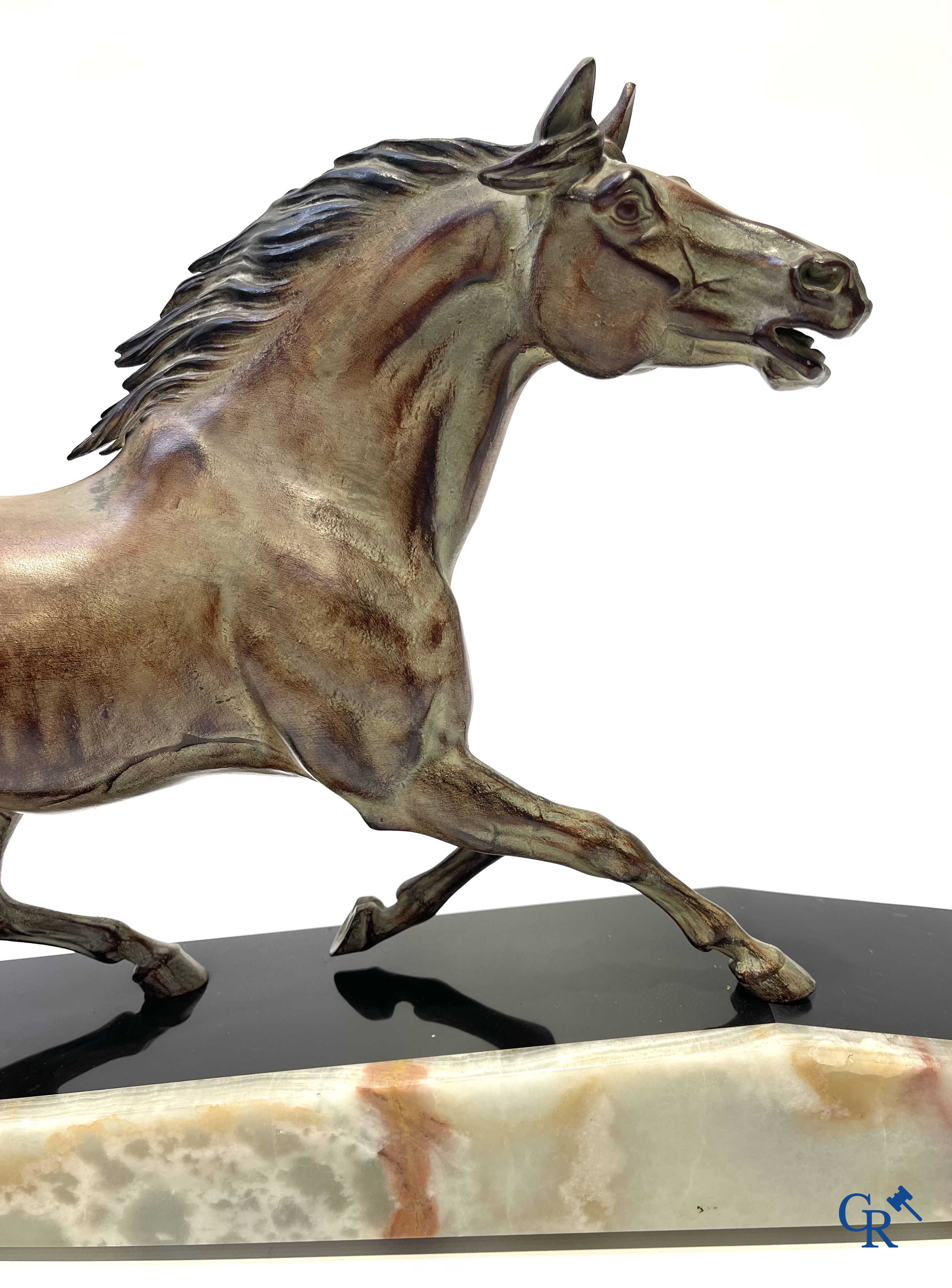 Voorstelling van een lopend paard op een sokkel in zwarte marmer en onyx. Gesigneerd Jonce.