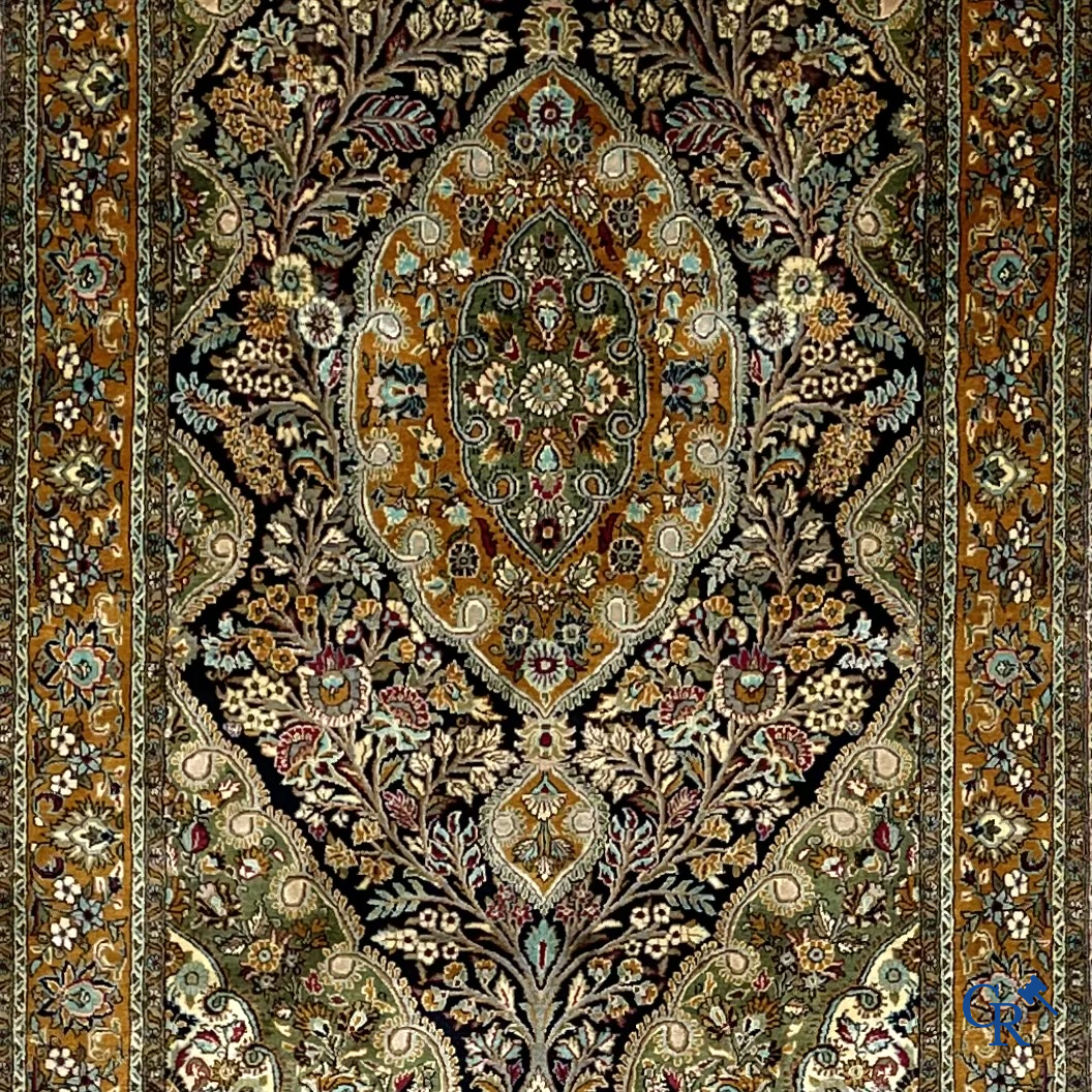 Oriental carpets. Hand-knotted silk carpet with floral decor on an orange background.
