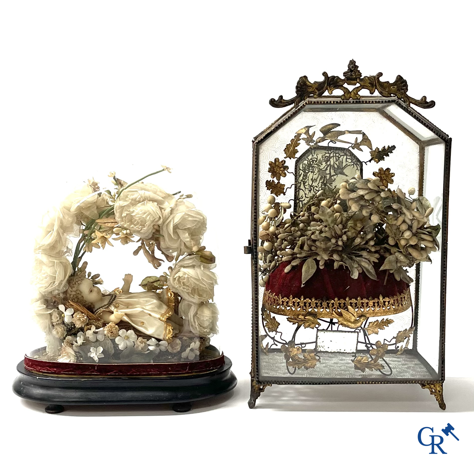 Een globe in glas met een kind in was en een vitrine in messing met bruidsboeket. Circa 1900.