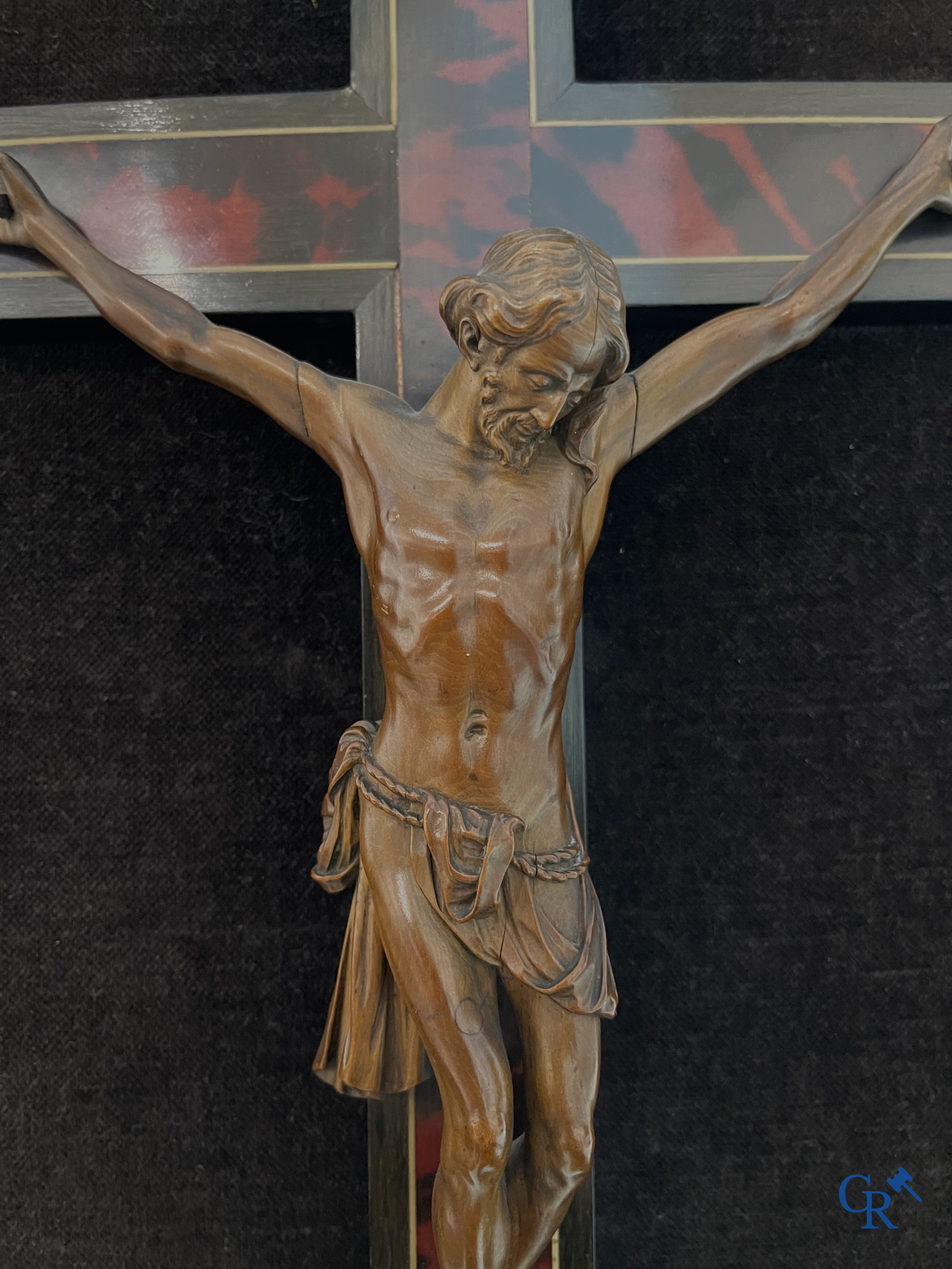 Corpus Christi in fijngesneden palmhout gemonteerd op kruis. Kader van de werkhuizen Franck te Antwerpen. 18e-19e eeuw.