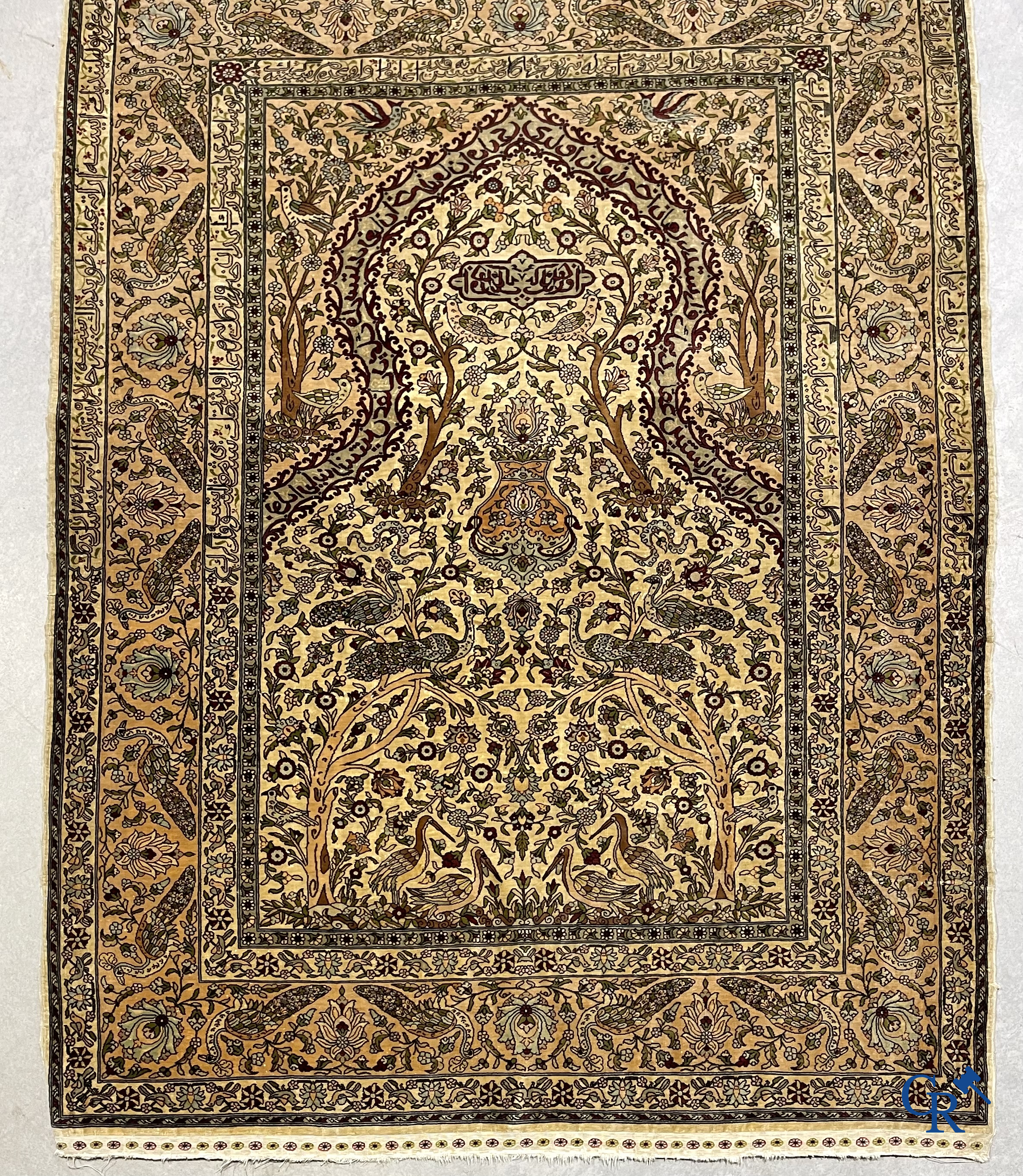 Oriental carpets. Hereke. A finely hand-knotted silk carpet with birds in the forest. Inscriptions and signed.
