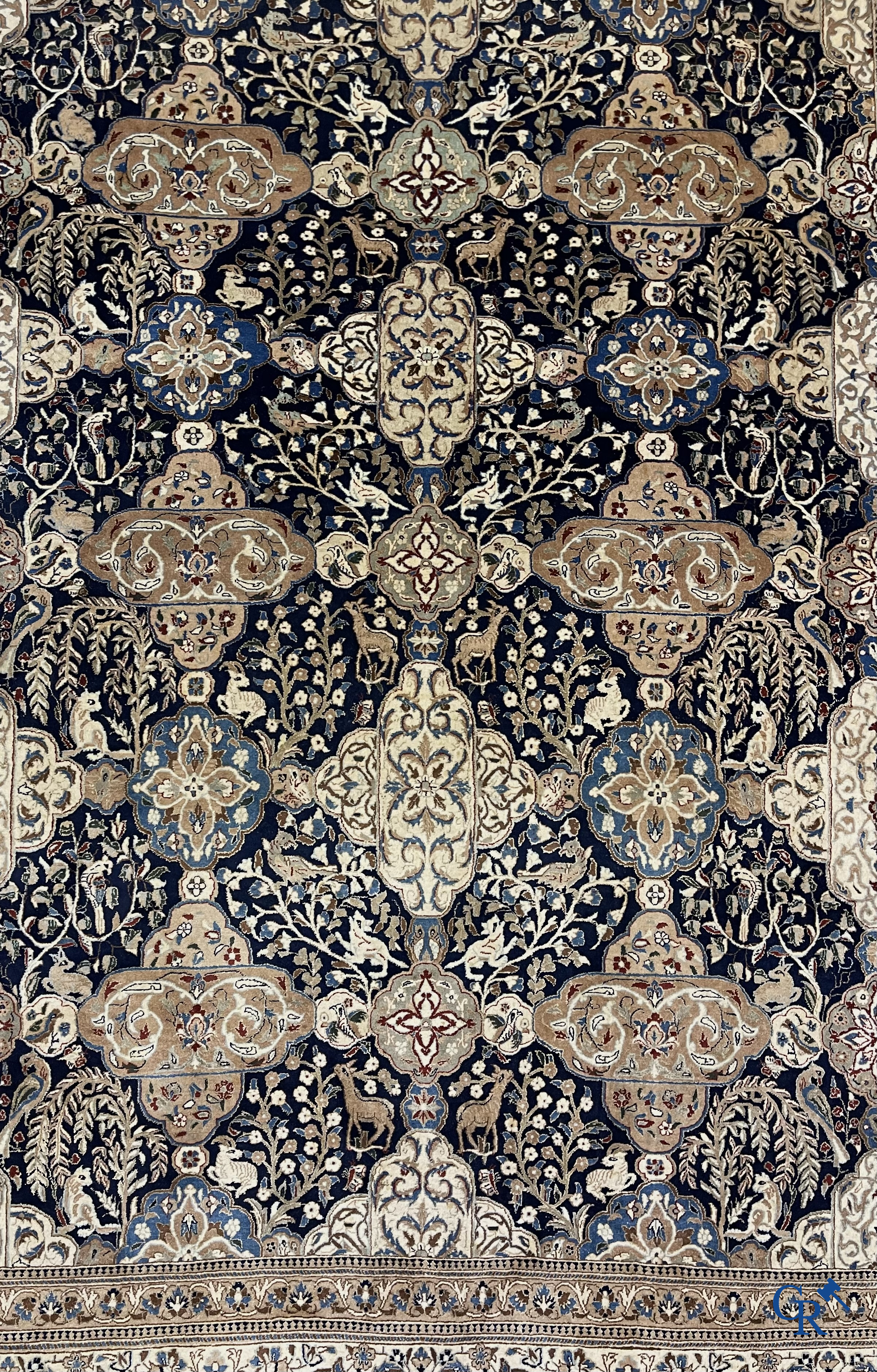 Oosterse tapijten. Een handgeknoopt tapijt met wouddieren en bloemen.