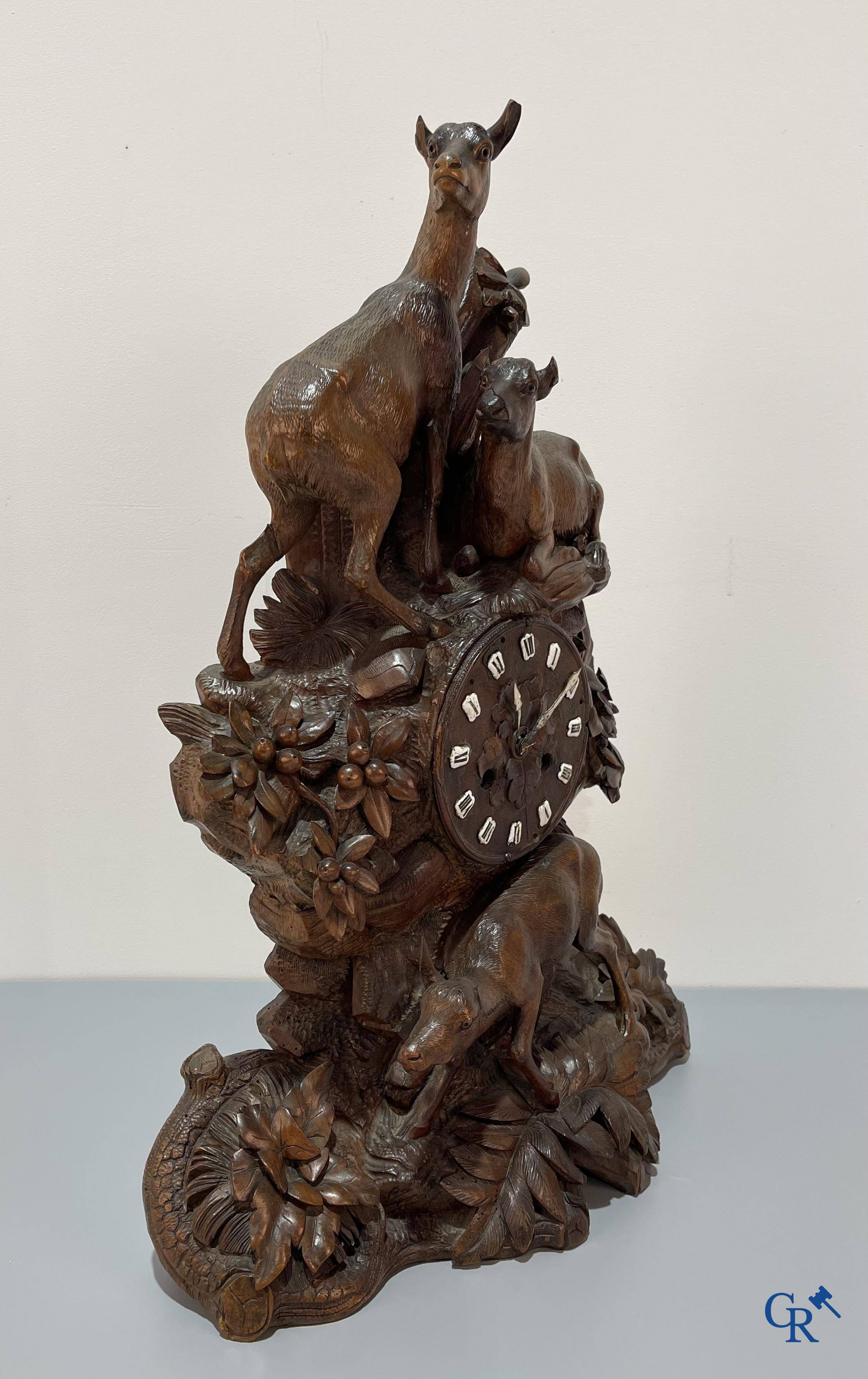 A wood sculpted Black Forest clock with deer in their flora. Germany, late 19th century.