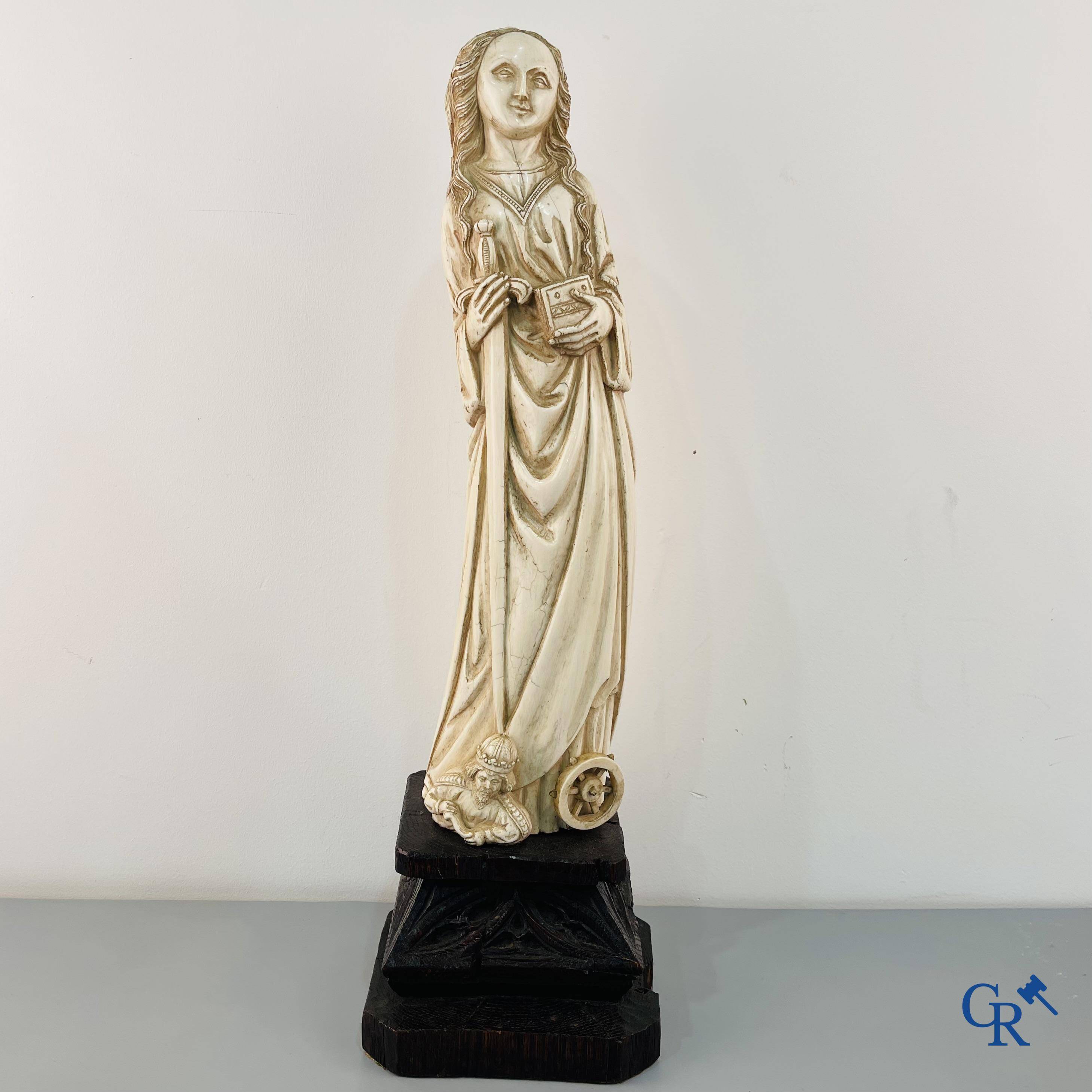 Représentation en ivoire de Sainte Catherine avec l'empereur Maxence sur un piédestal néo-gothique en bois. 