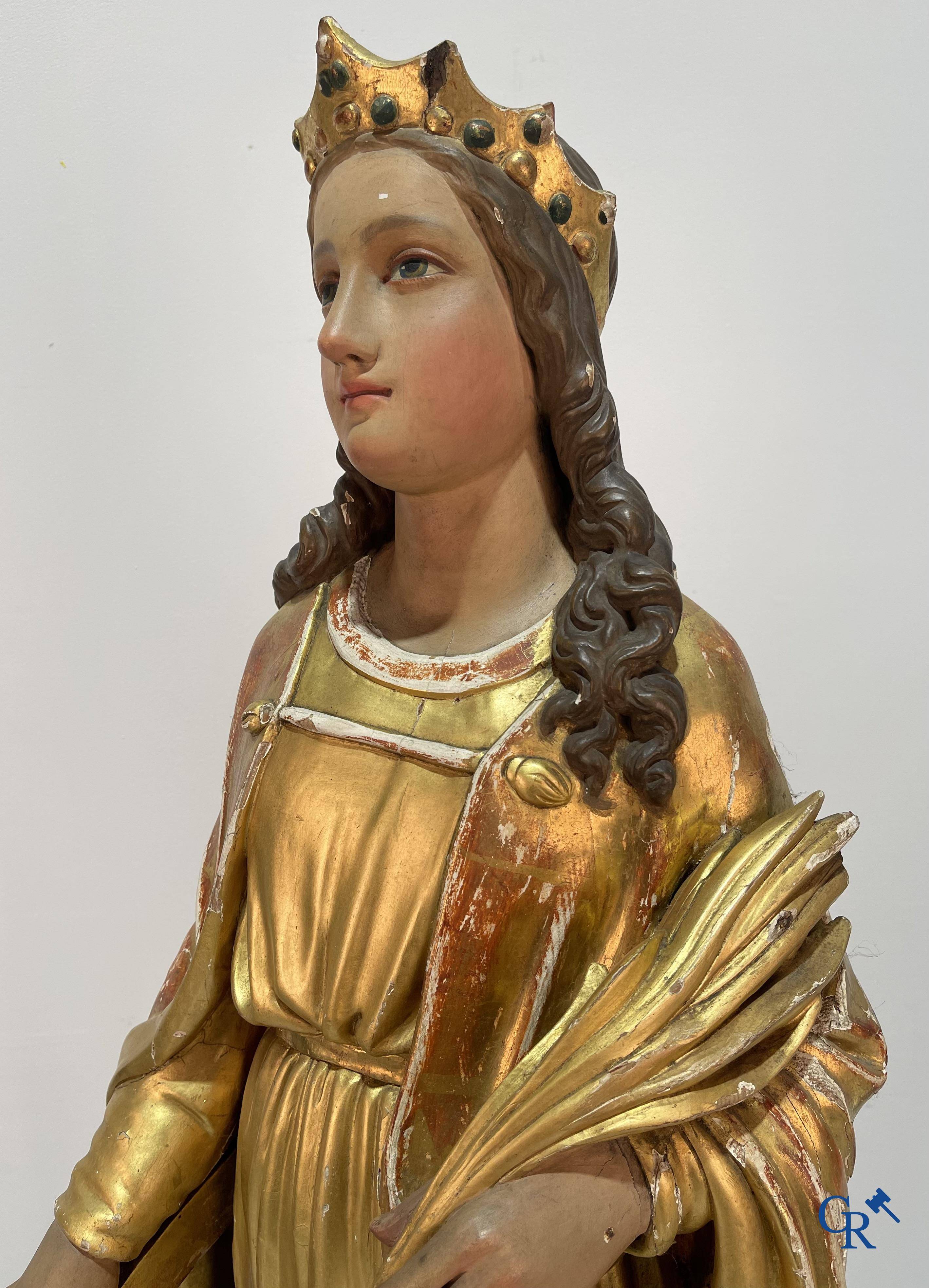 A large gilded and polychrome wooden statue of Saint Catherine of Alexandria.