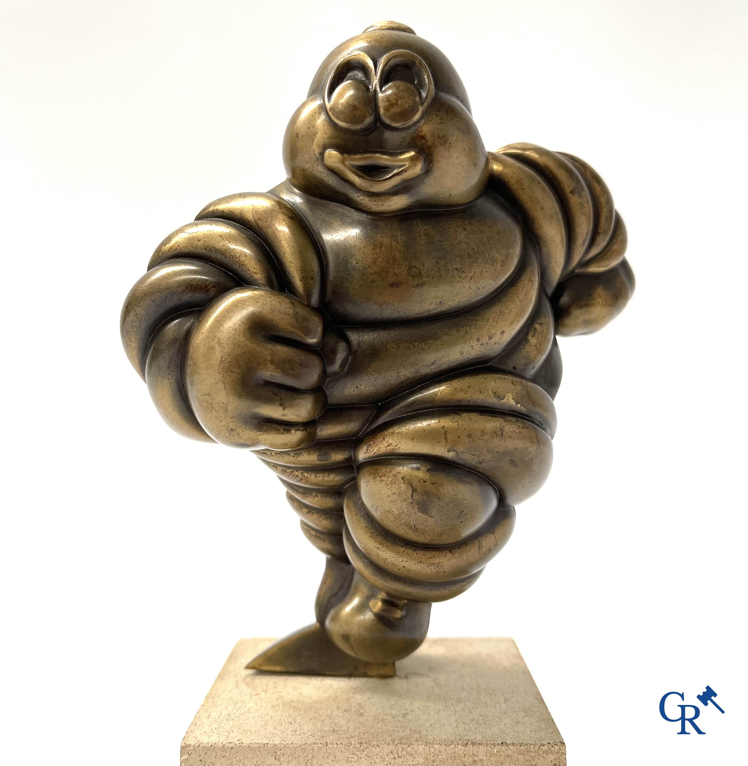 Michelin, Presentation of a running Bibendum in patinated bronze on a stone pedestal. Signed Gerard.