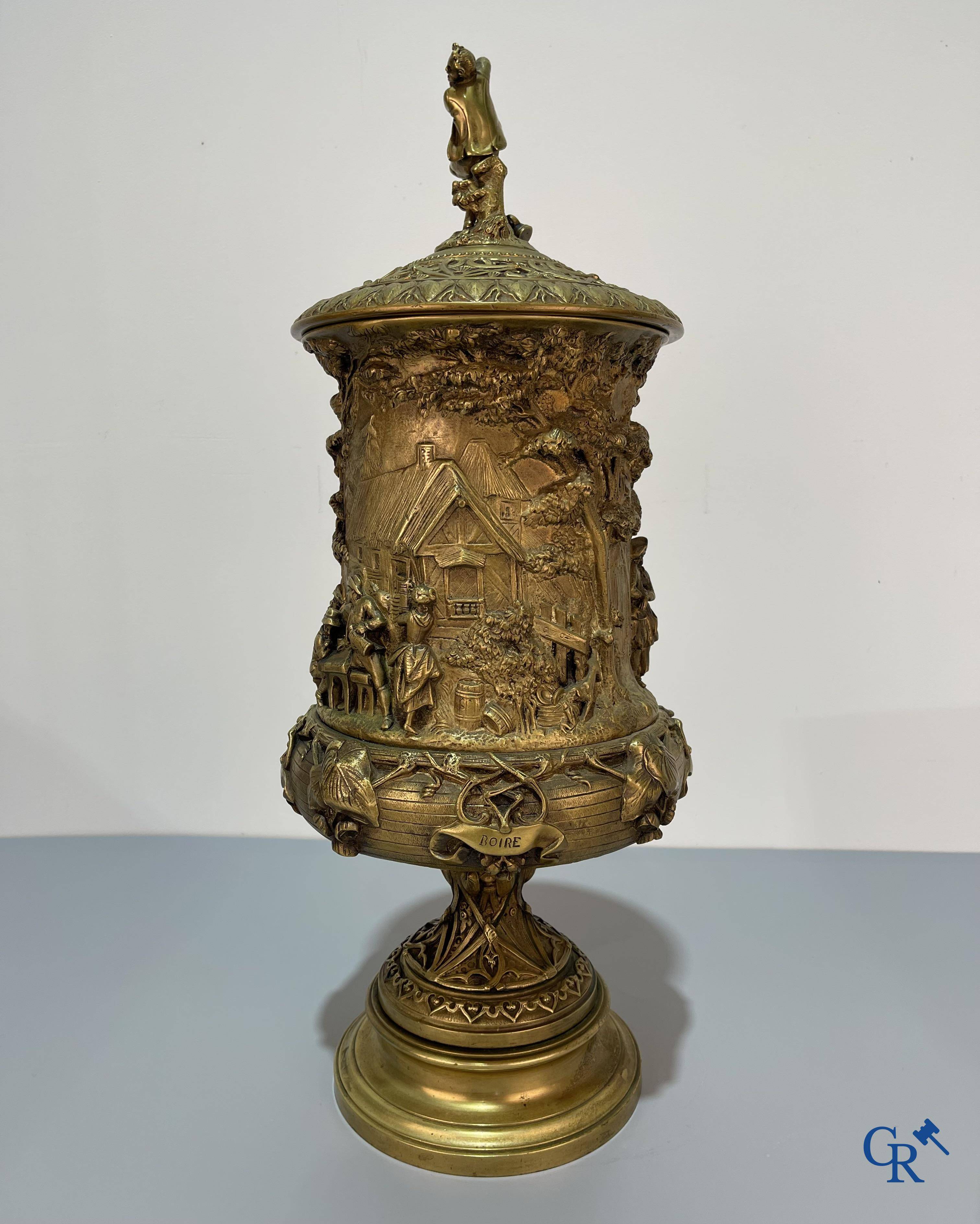 Un imposant pot à tabac en bronze finement travaillée avec les inscriptions "aimer, danser, fumer, boire".<br />
19ème siècle.