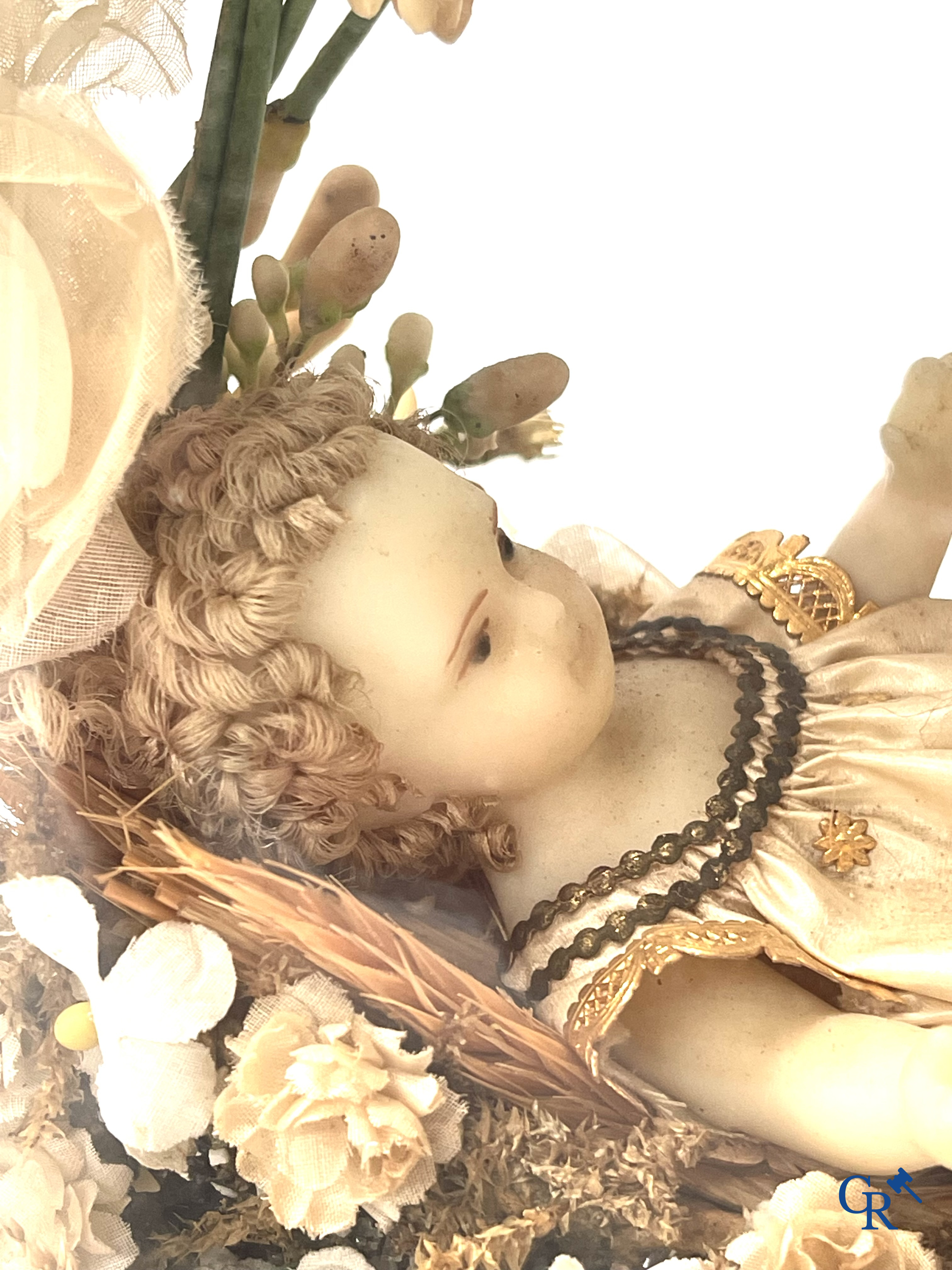 A globe in glass with a child in wax and a brass display case with bridal bouquet. Around 1900.