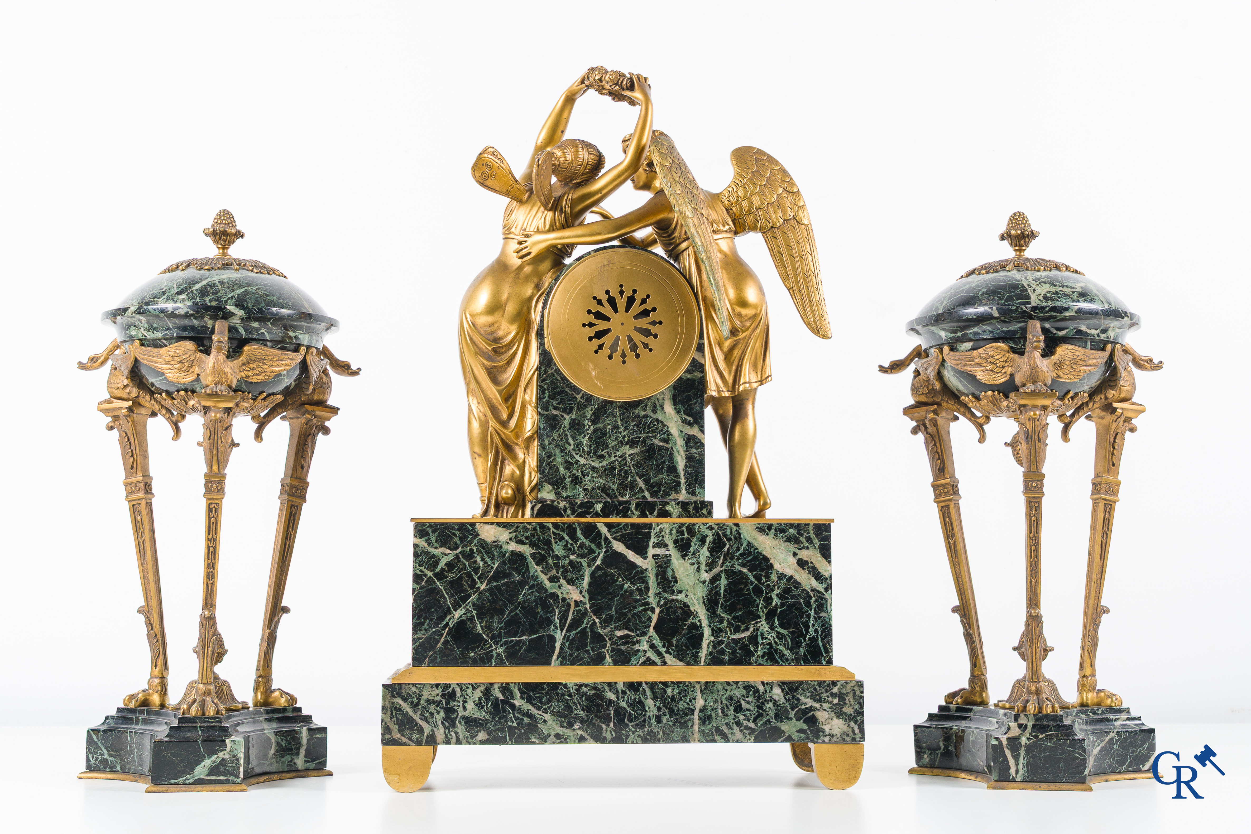 Een 3-delige schouwgarnituur in groen geaderde marmer en vergulde brons. Empire stijl. Circa 1900.