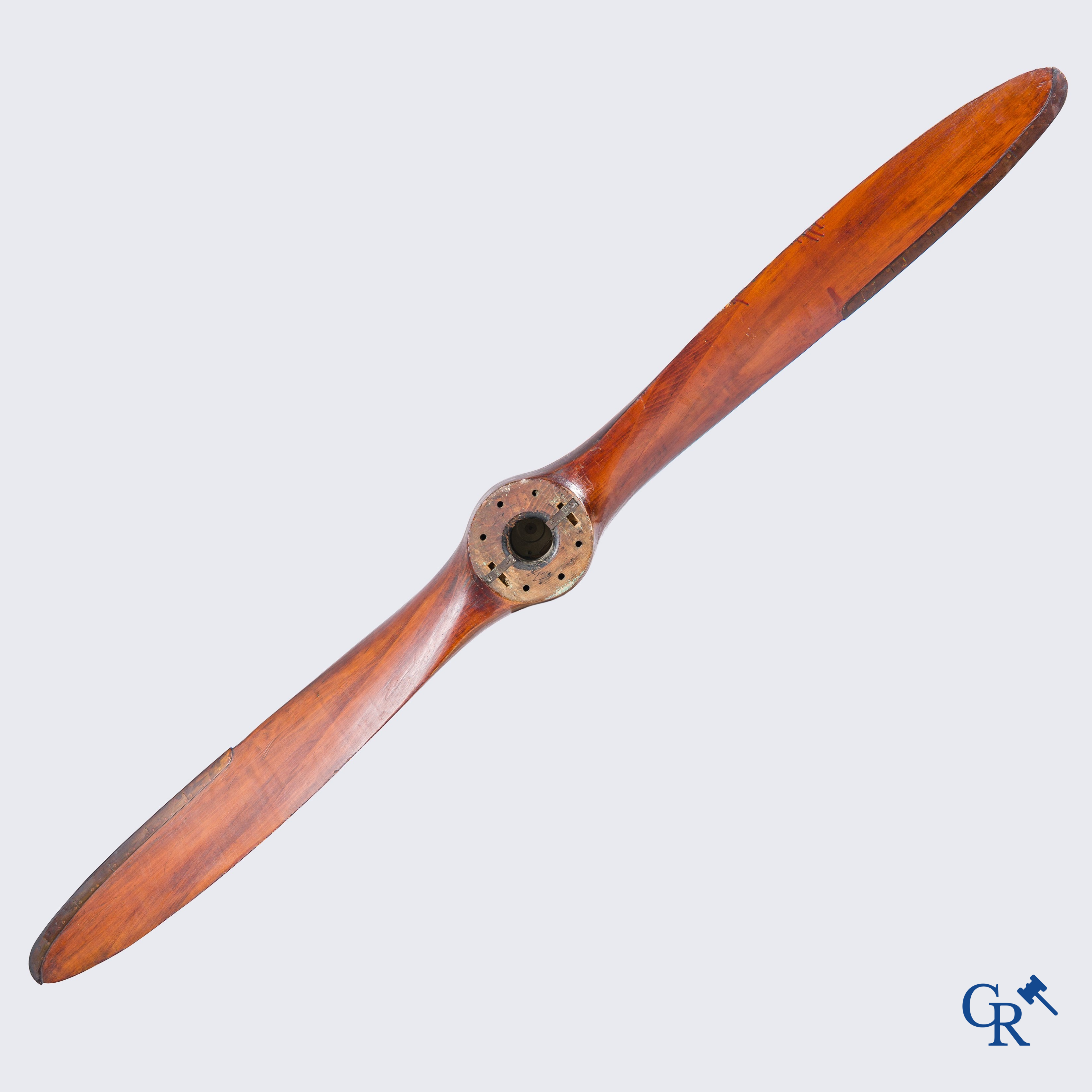 Een grote houten propeller of luchtschroef met koperbeslag en later ingewerkt uurwerk.