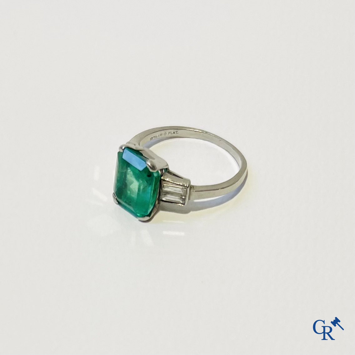 Juwelen. Een platina ring met smaragd en diamanten en een hanger in witgoud 750°/00 met smaragd en 14 diamanten.