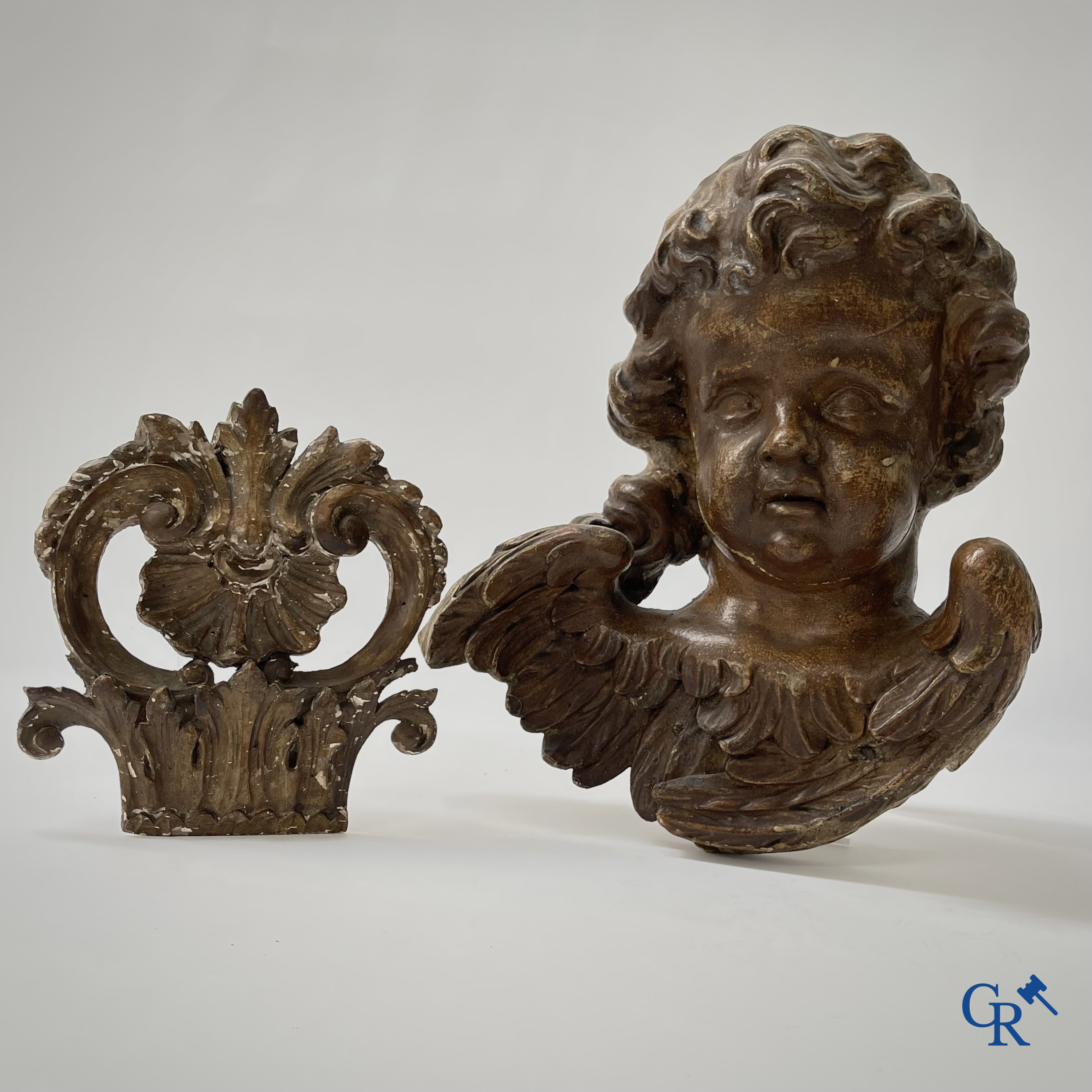 Religieuze Objecten. Barok. Een hout gesculpteerd hoofd van een engel en een ornament in gesculpteerd hout. 18e eeuw.