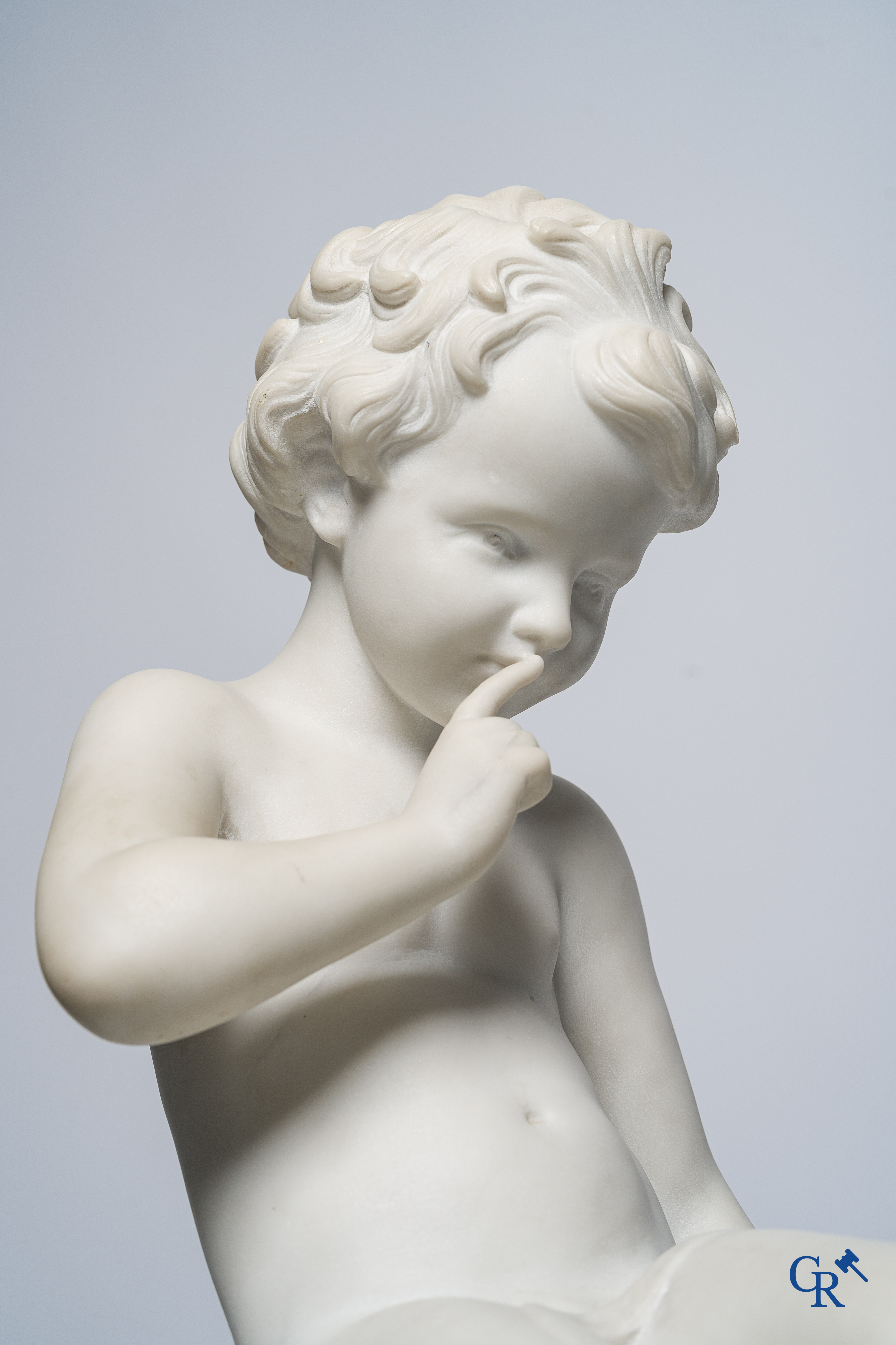Voorstelling van een zittende cupido in Carrara marmer. In de stijl van Jean-Baptiste Pigalle. Circa 1900..