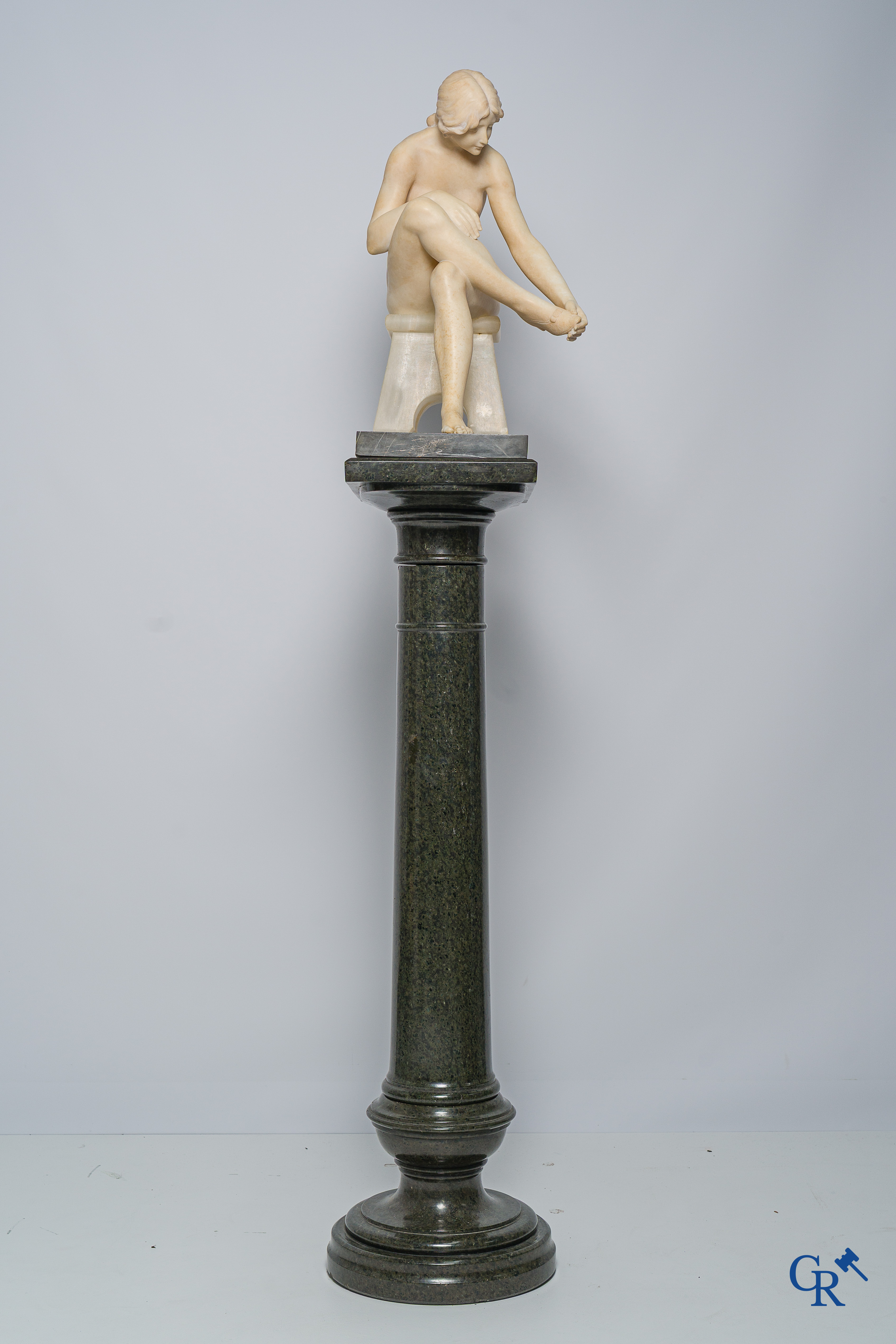 Art Nouveau. Marmeren beeld van een zittende jongedame op stoel. Bijhorende sokkel in serpentine. Circa 1910.