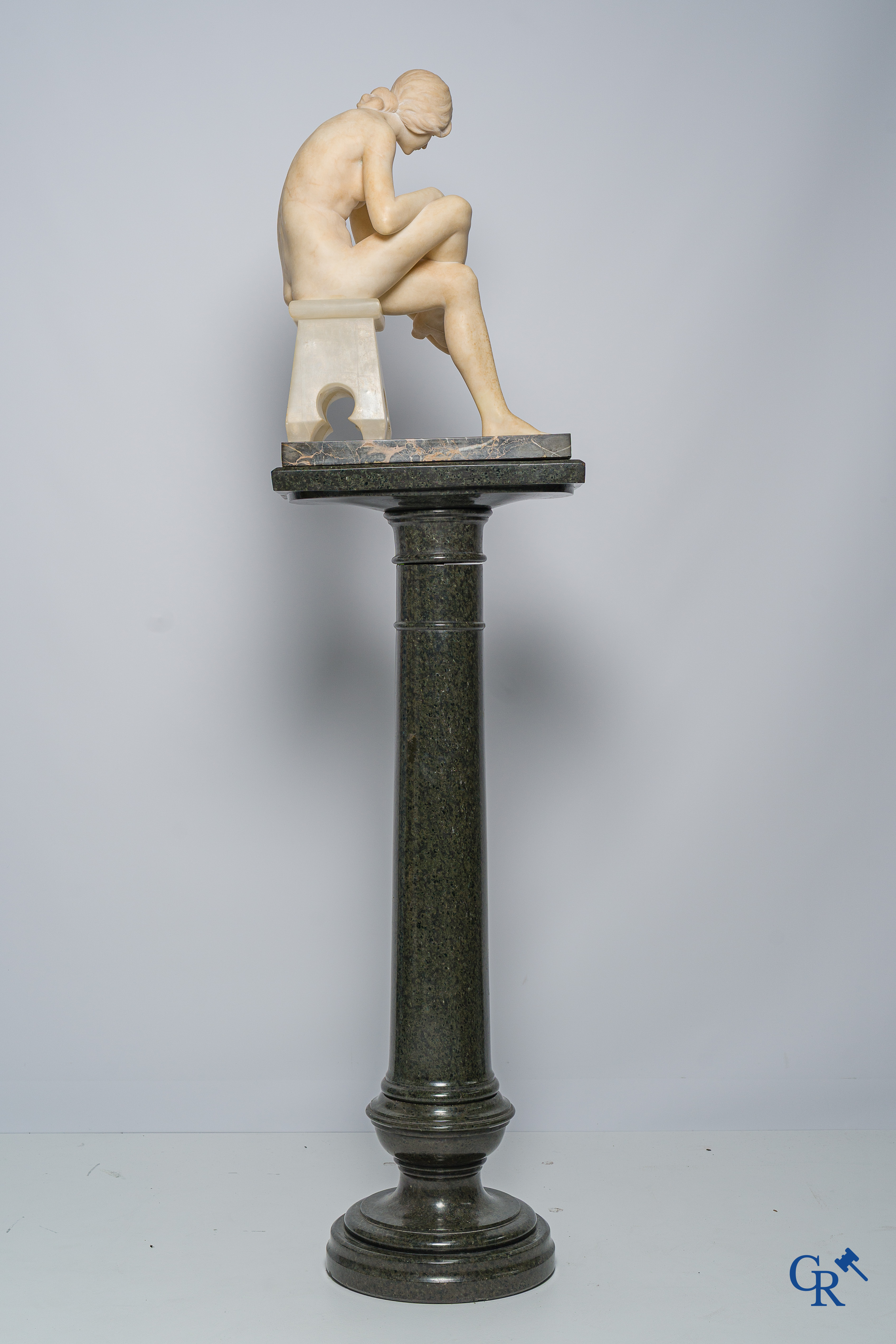 Art Nouveau. Marmeren beeld van een zittende jongedame op stoel. Bijhorende sokkel in serpentine. Circa 1910.