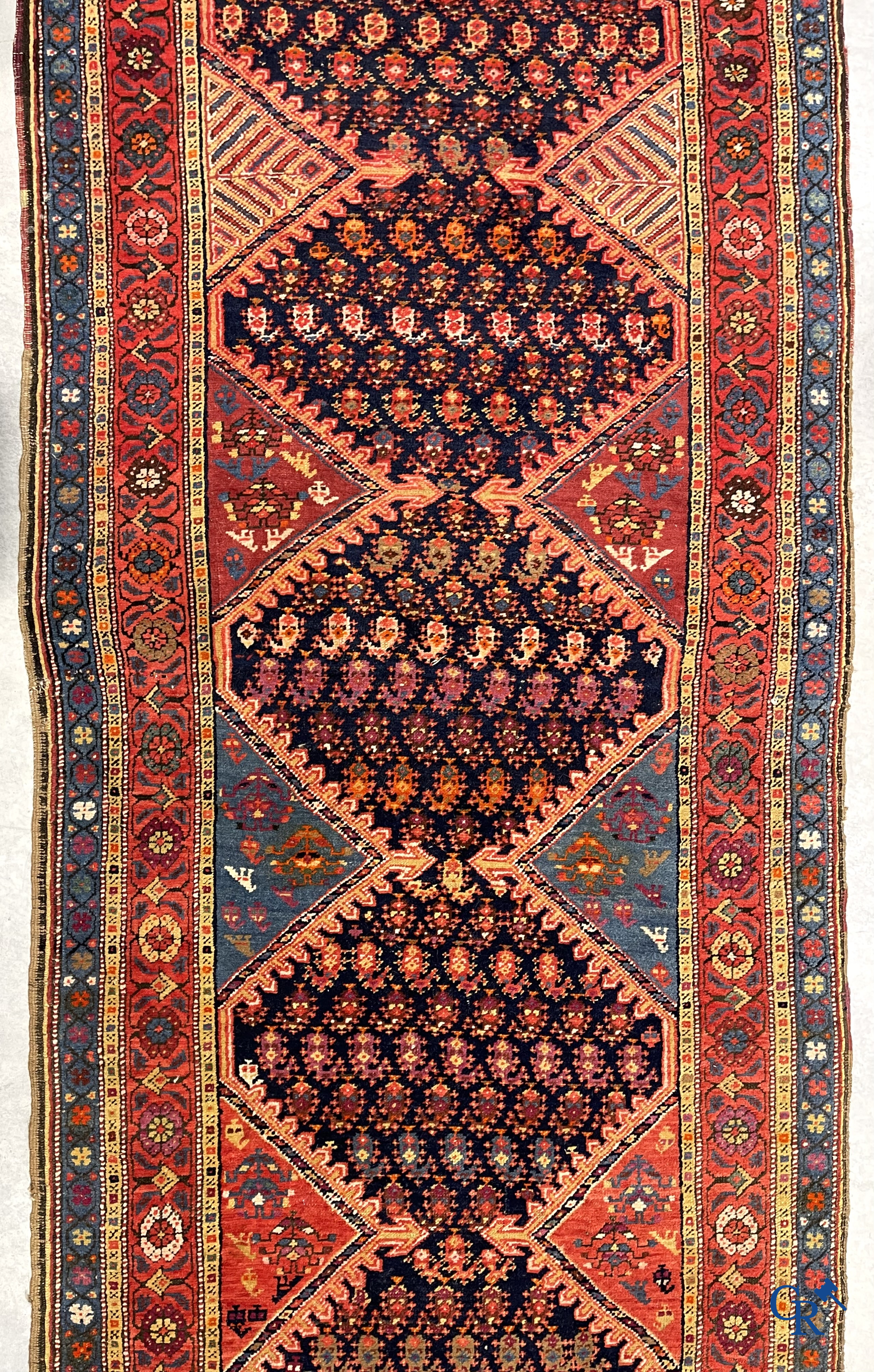 Oriental carpets. A large hand-knotted antique runner with geometric motifs. 19th century.