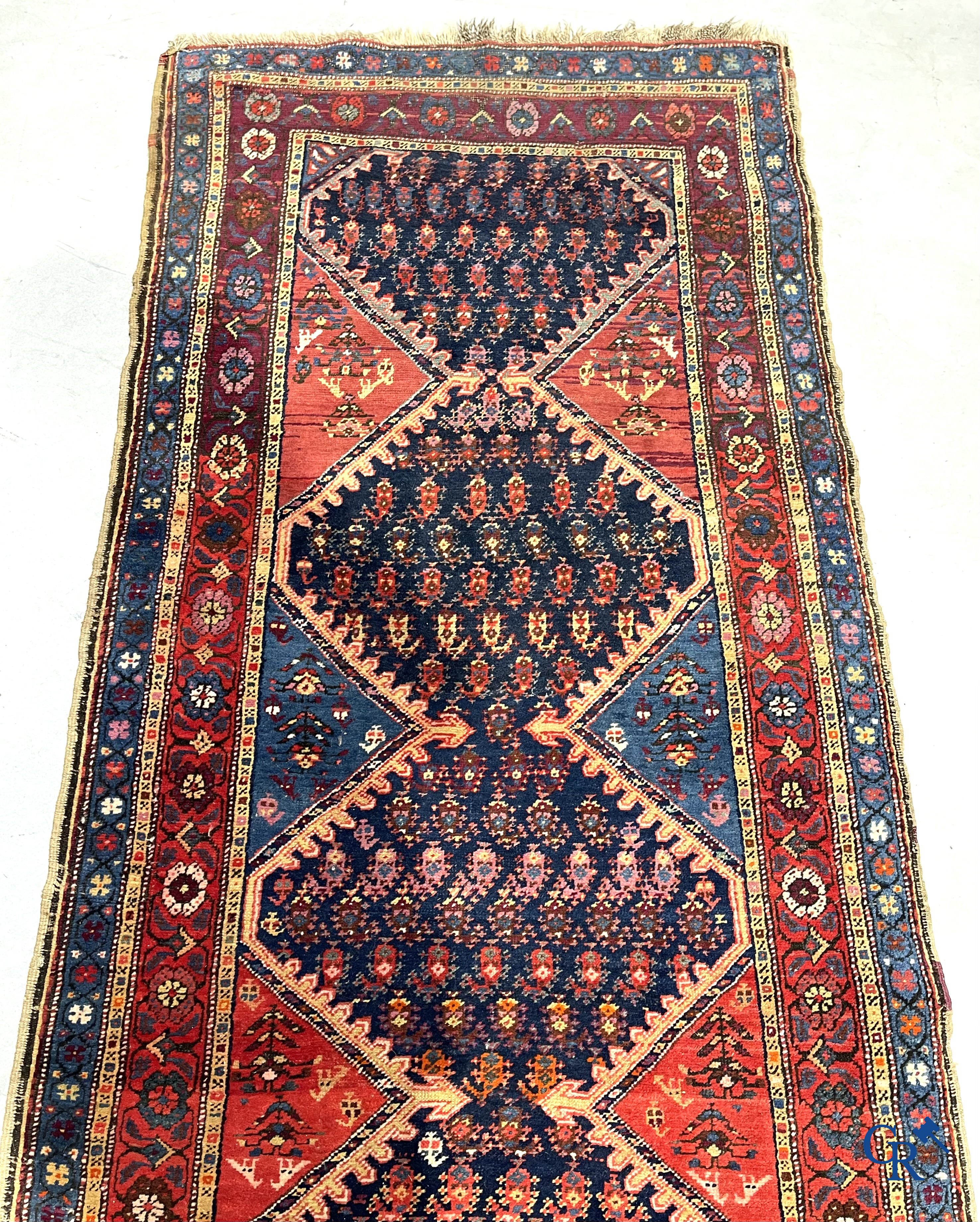 Oriental carpets. A large hand-knotted antique runner with geometric motifs. 19th century.