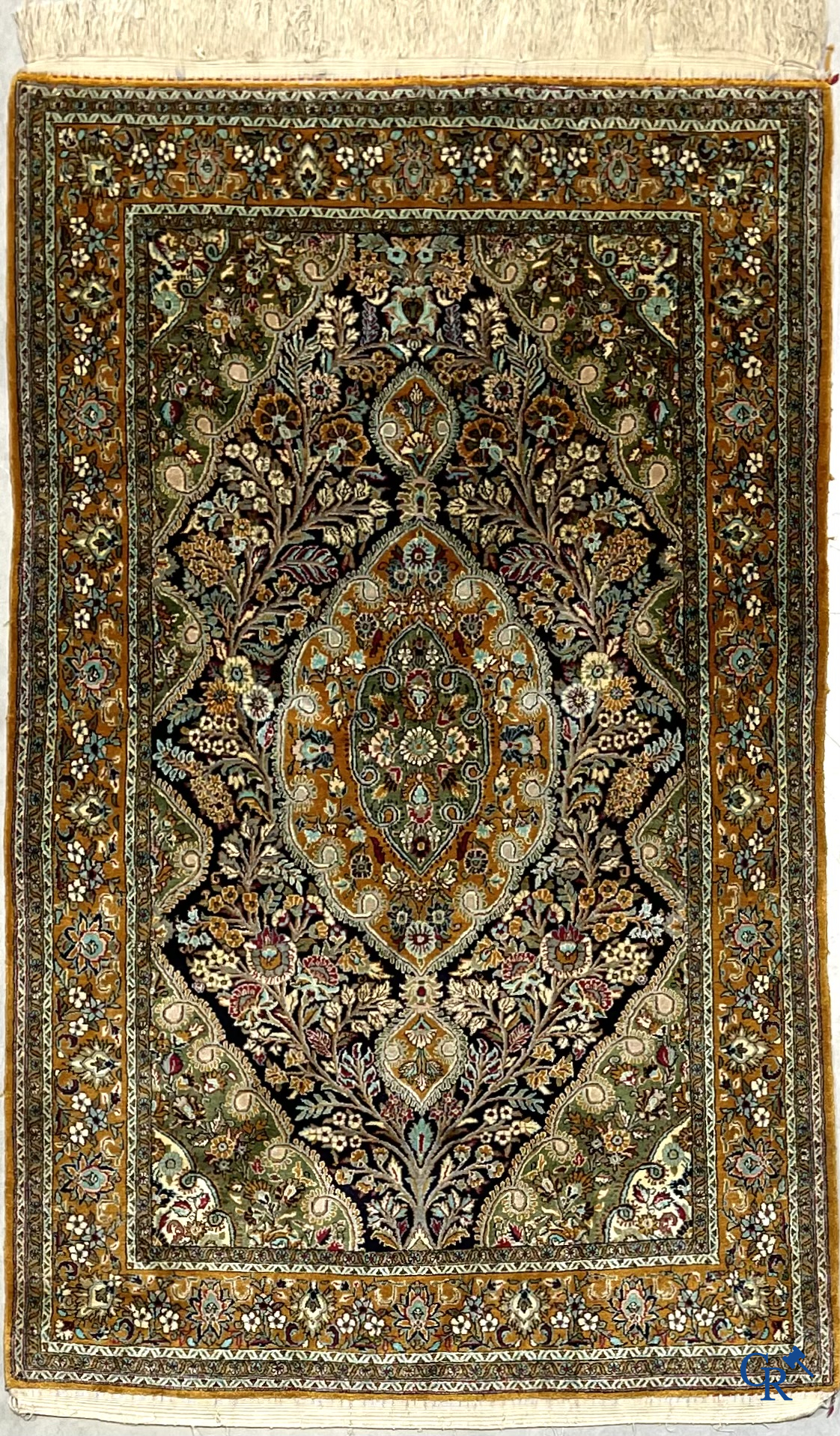 Oriental carpets. Hand-knotted silk carpet with floral decor on an orange background.