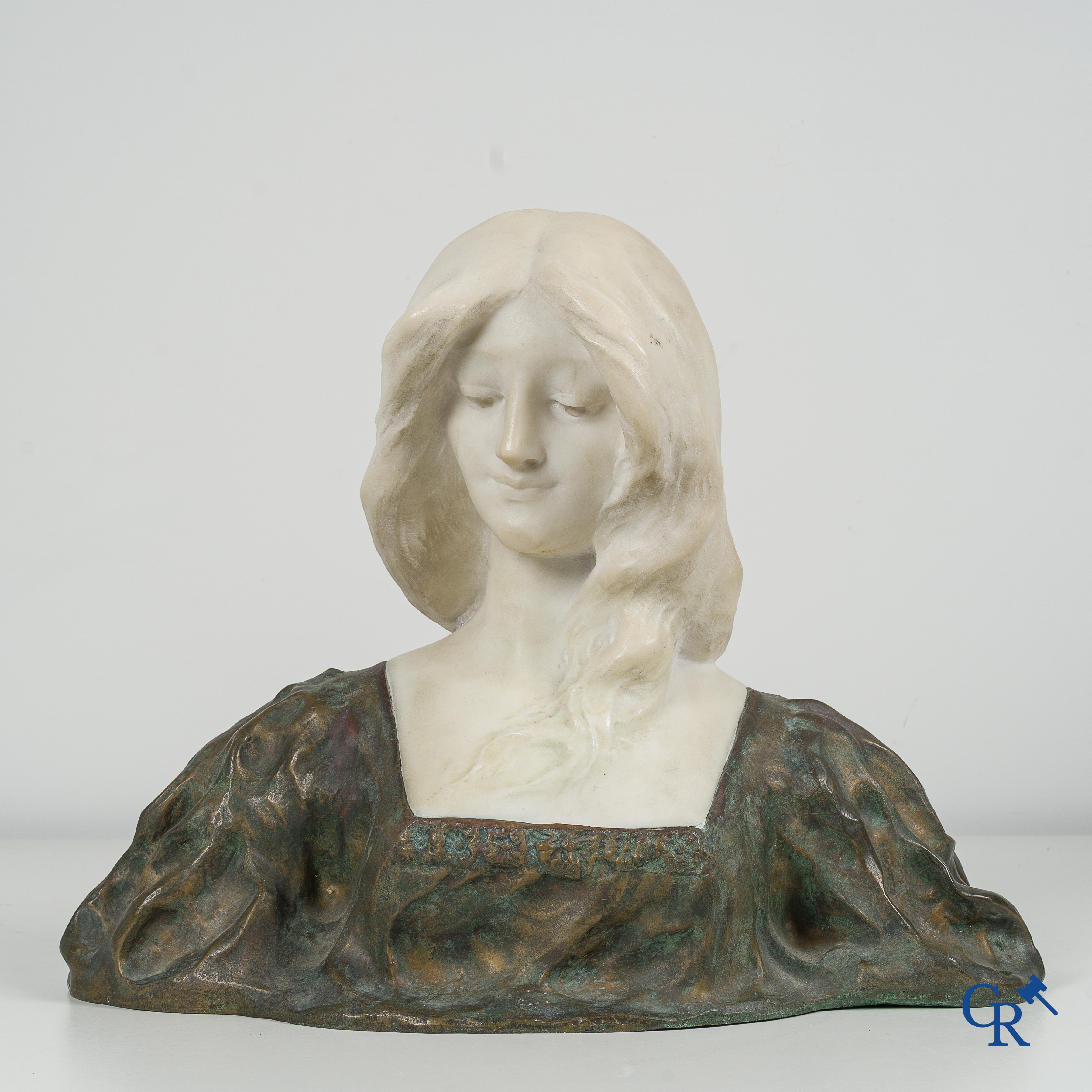 Art Nouveau. Bust of a young lady in Carrara marble and brown-green patinated bronze. Signed, circa 1900.