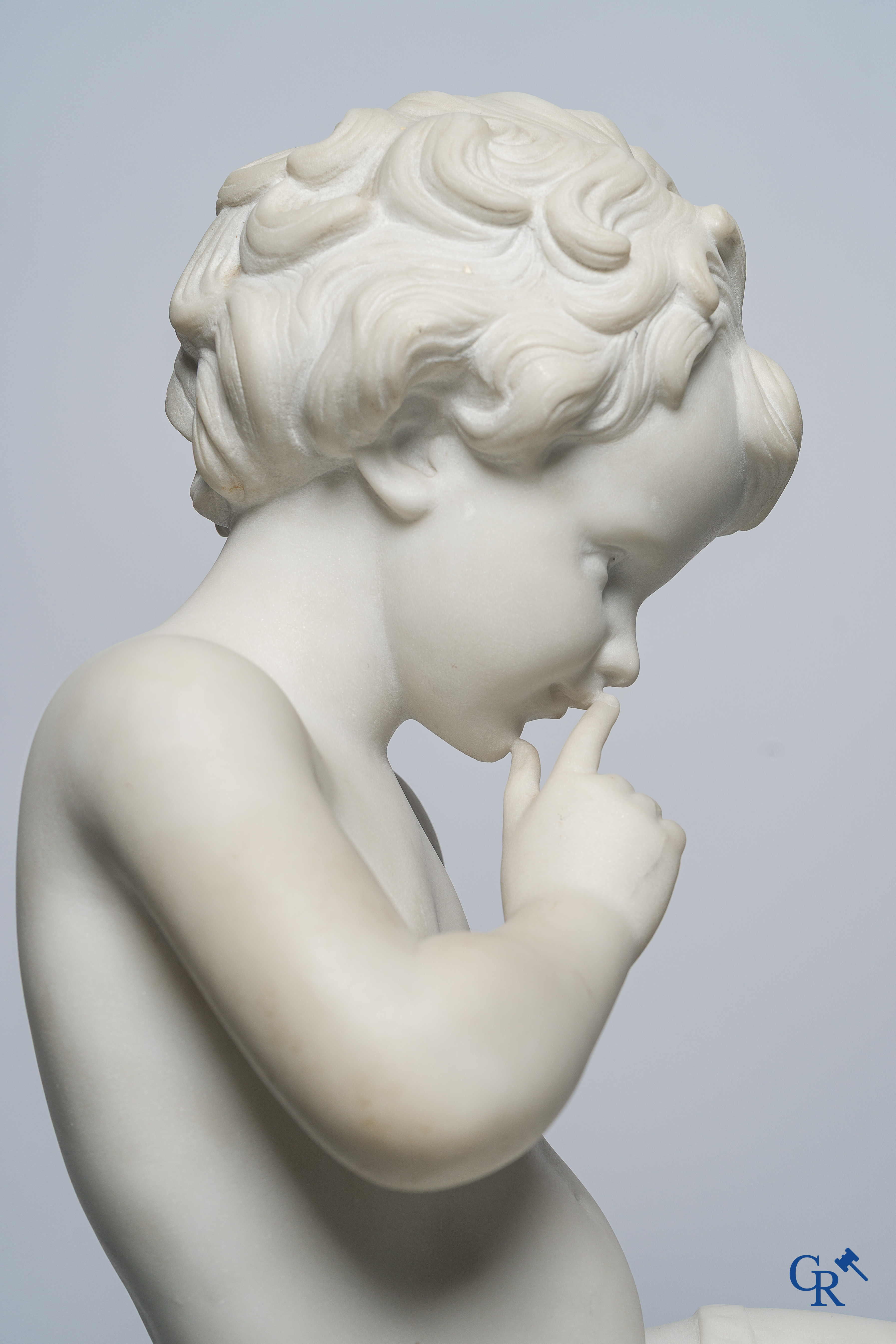 Voorstelling van een zittende cupido in Carrara marmer. In de stijl van Jean-Baptiste Pigalle. Circa 1900..