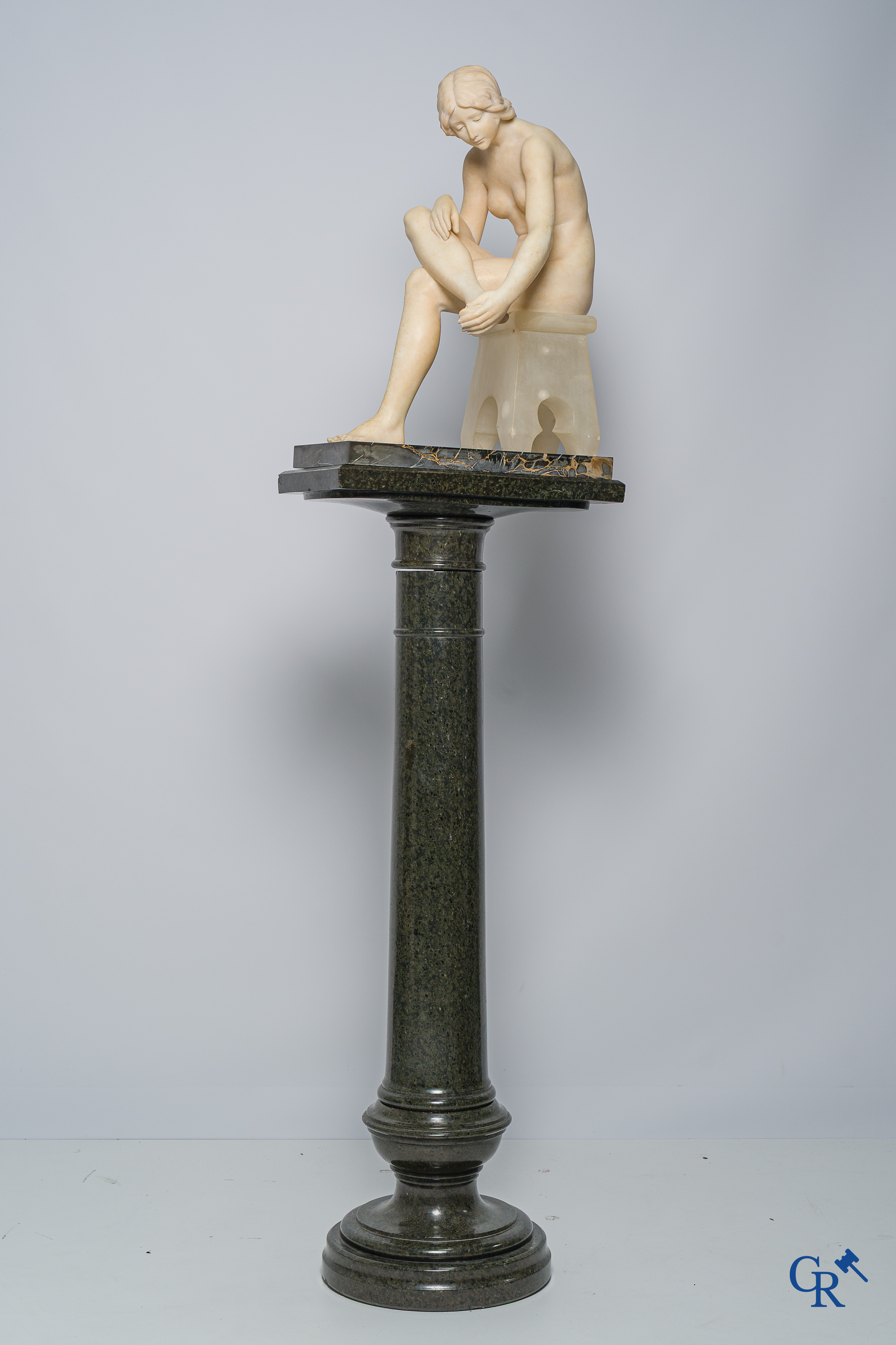 Art Nouveau. Marmeren beeld van een zittende jongedame op stoel. Bijhorende sokkel in serpentine. Circa 1910.