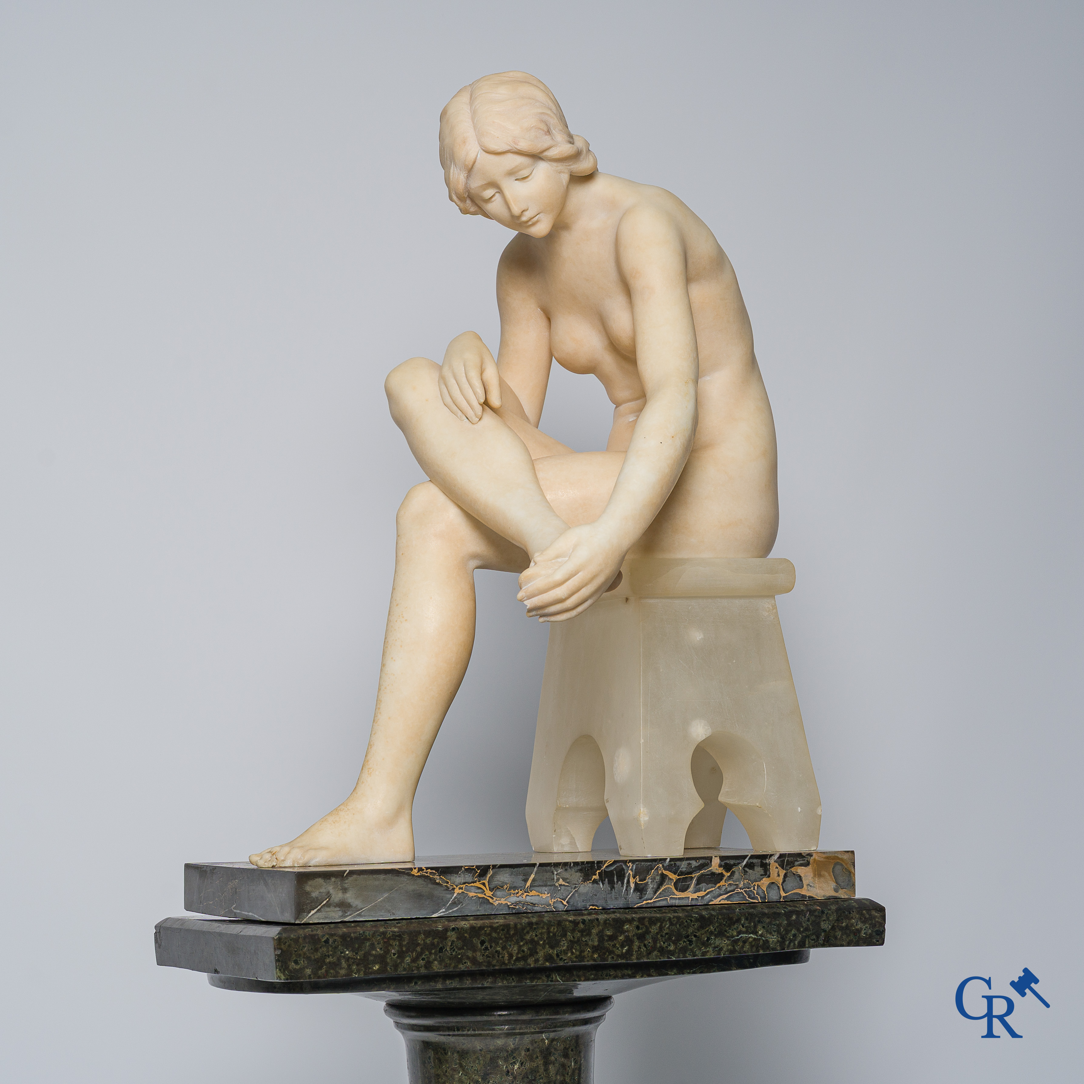 Art Nouveau. Marmeren beeld van een zittende jongedame op stoel. Bijhorende sokkel in serpentine. Circa 1910.