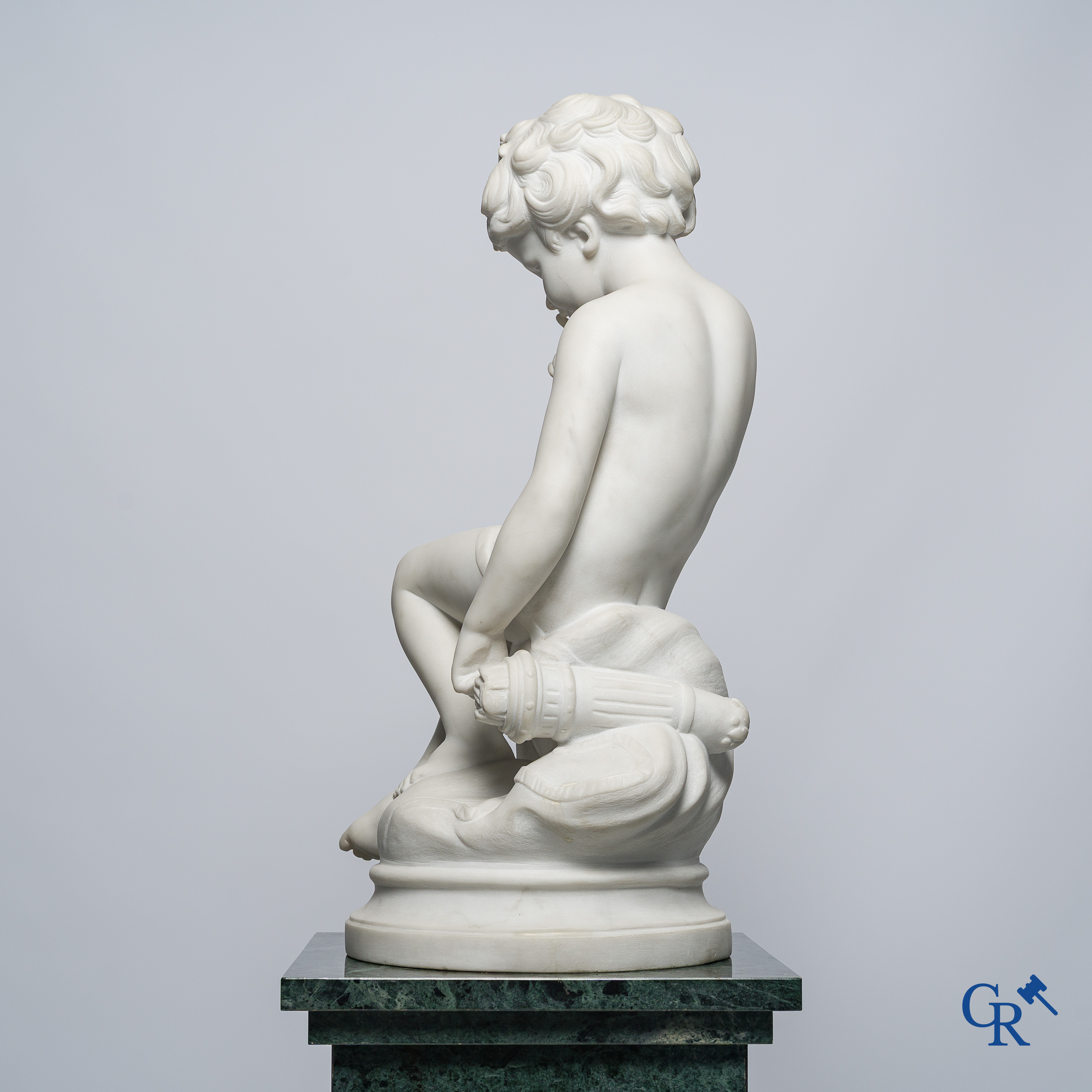 Voorstelling van een zittende cupido in Carrara marmer. In de stijl van Jean-Baptiste Pigalle. Circa 1900..