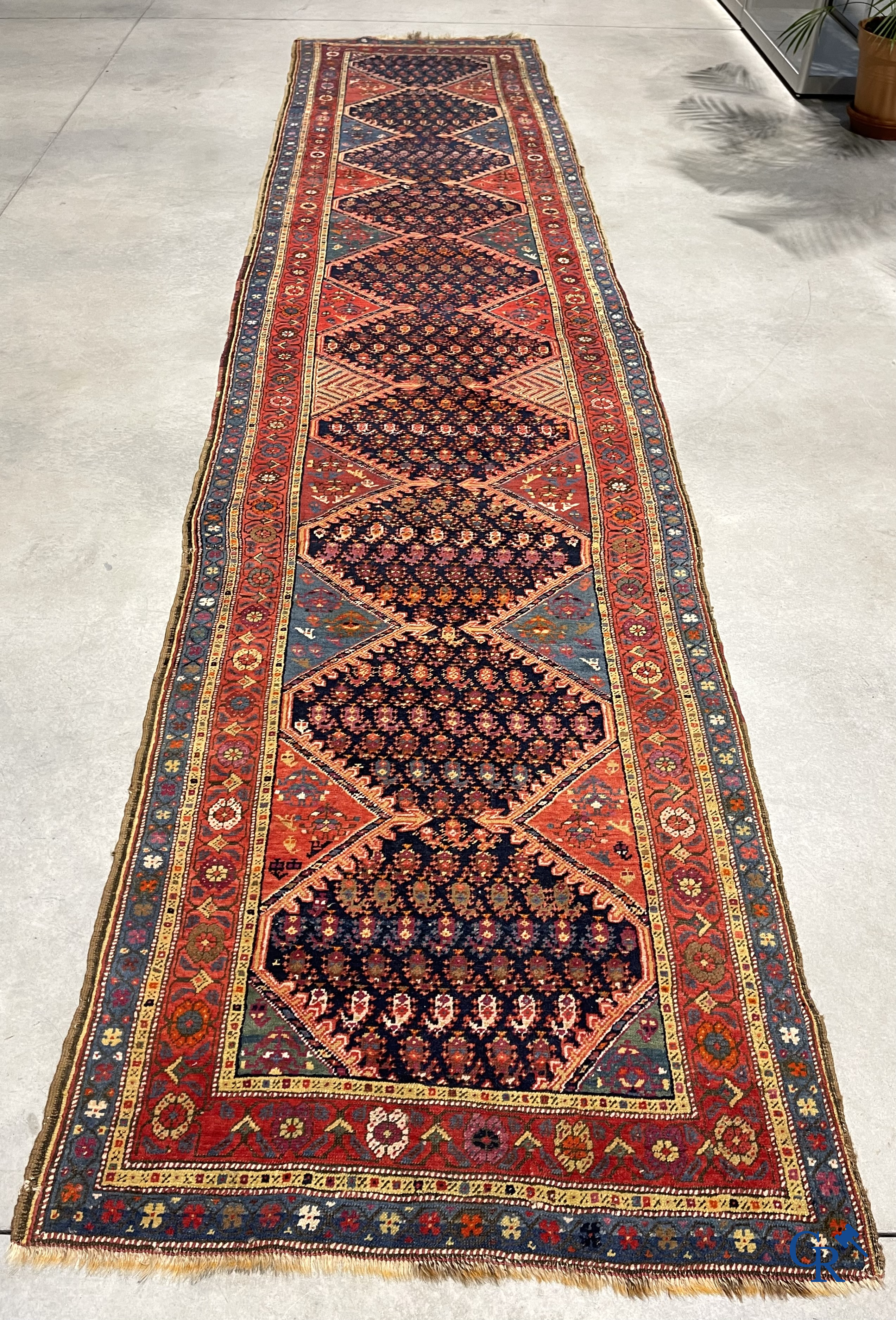 Oriental carpets. A large hand-knotted antique runner with geometric motifs. 19th century.