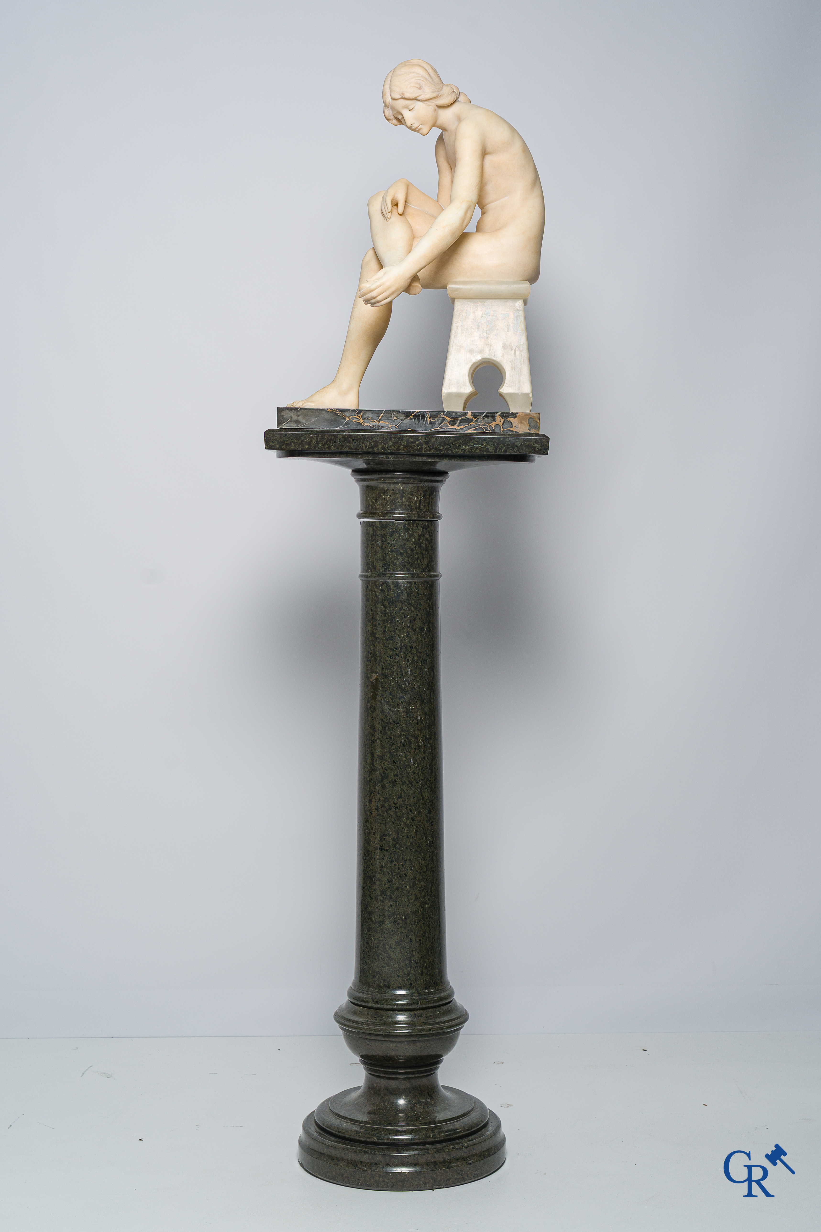 Art Nouveau. Marmeren beeld van een zittende jongedame op stoel. Bijhorende sokkel in serpentine. Circa 1910.